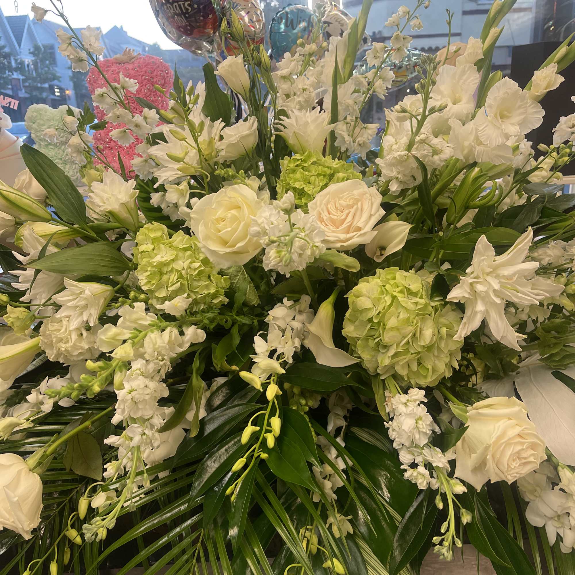 An all white tribute, this half casket spray is pure in color