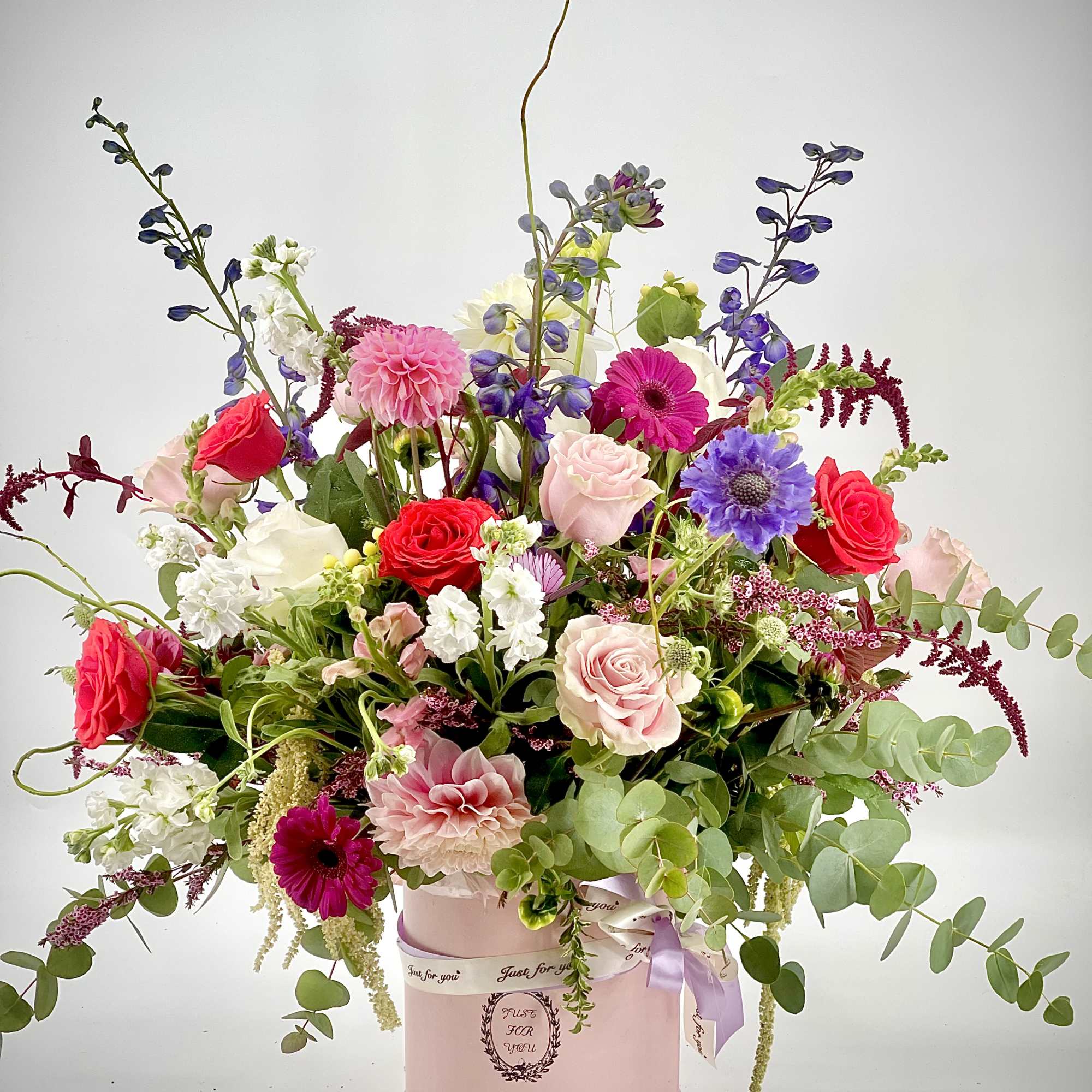 Mixed bouquet in a pink hat box with roses and gerbera daisies
