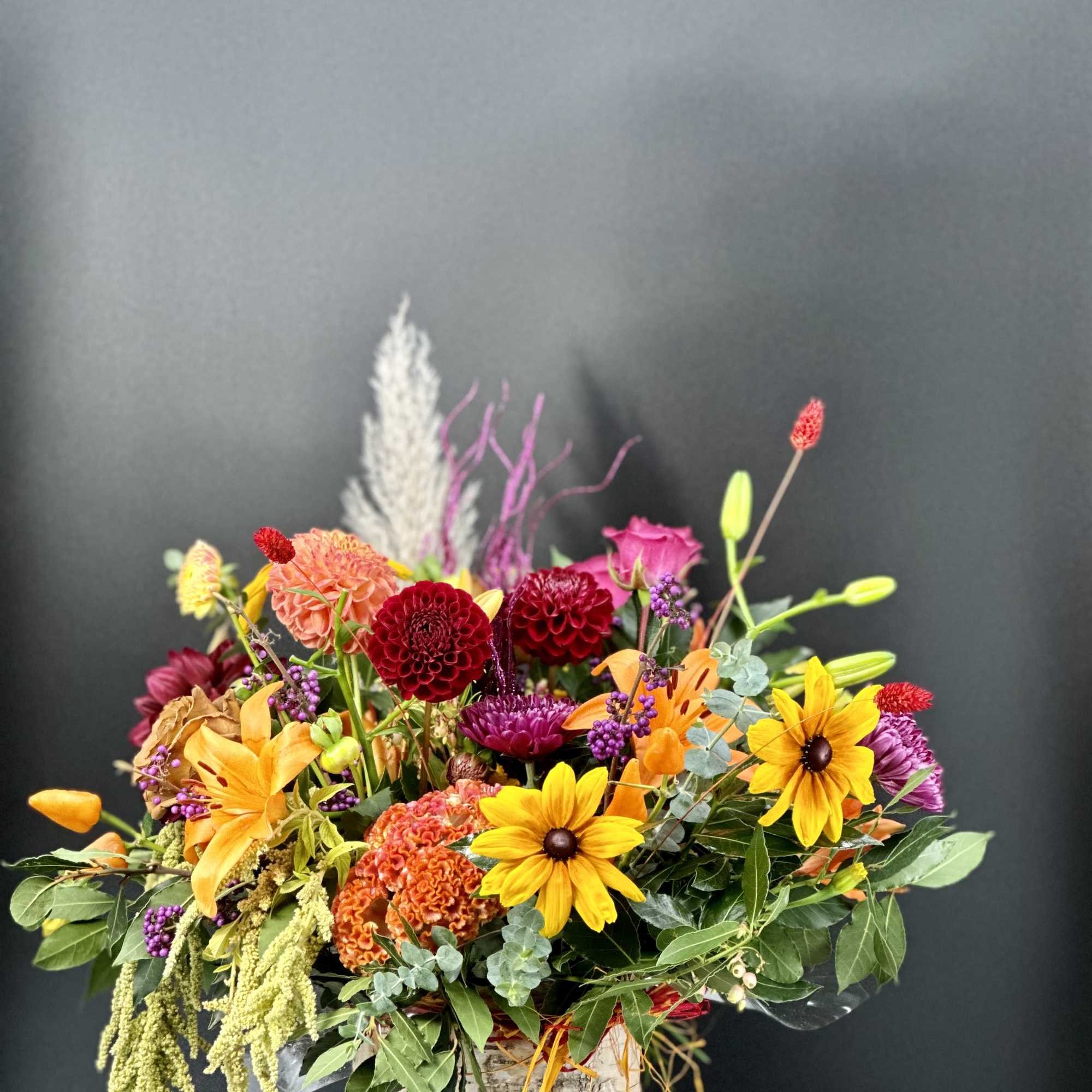 Colorful mixed flower arrangement in a birch bark container