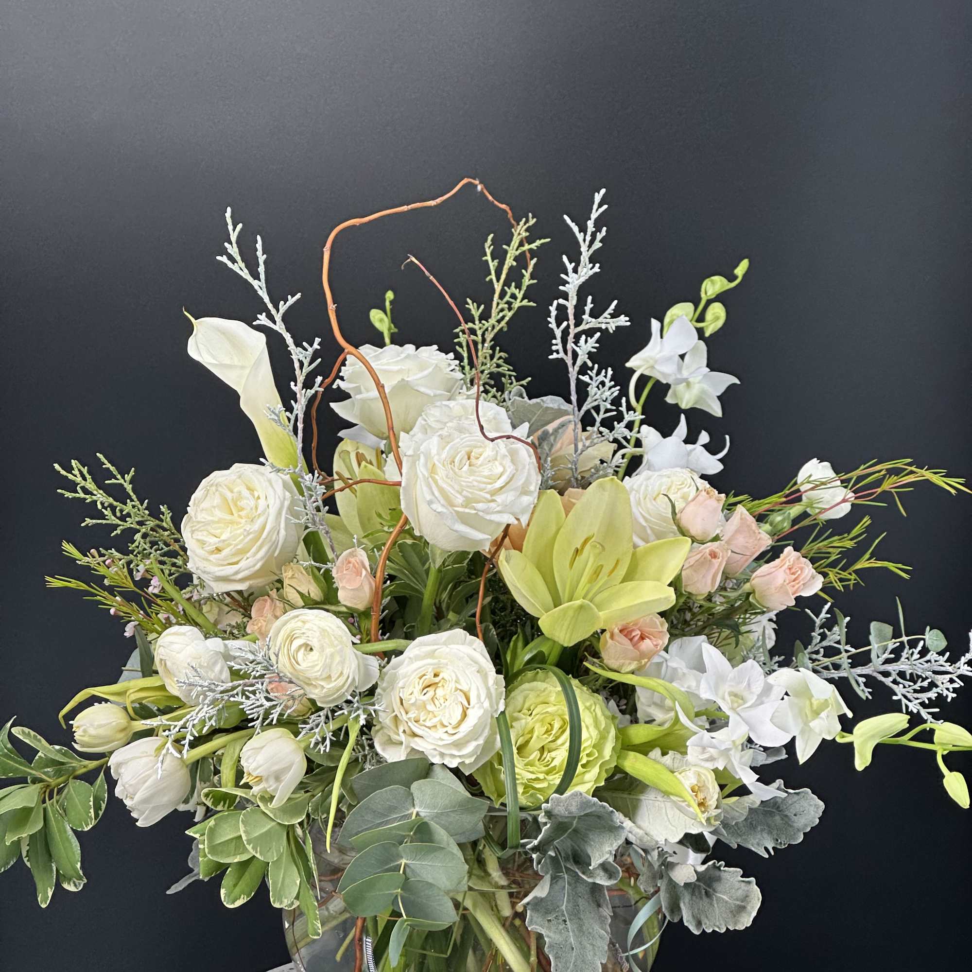 White and pale green floral arrangement in a glass bowl vase