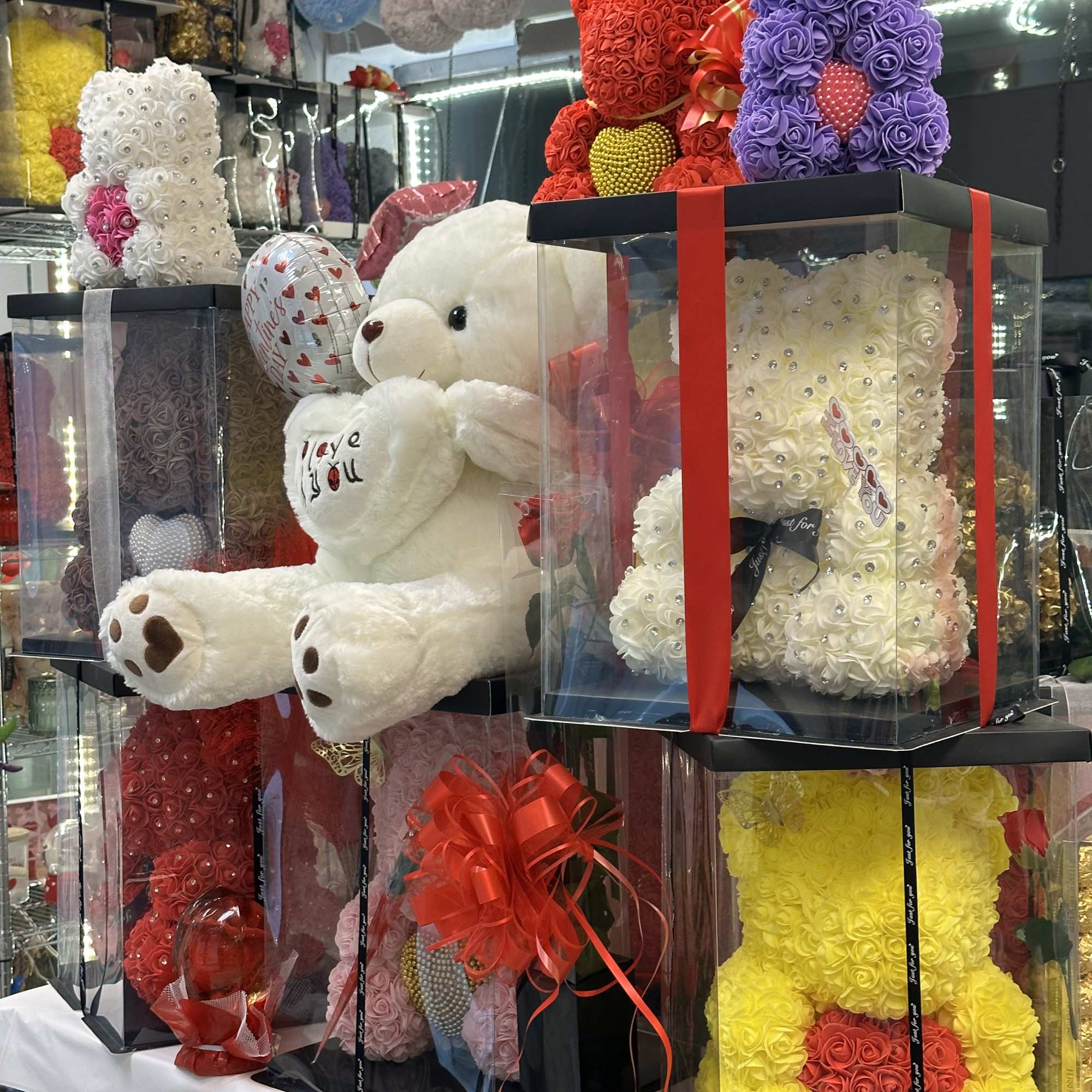 Gift boxes with rose teddy bears and a plush teddy bear on display