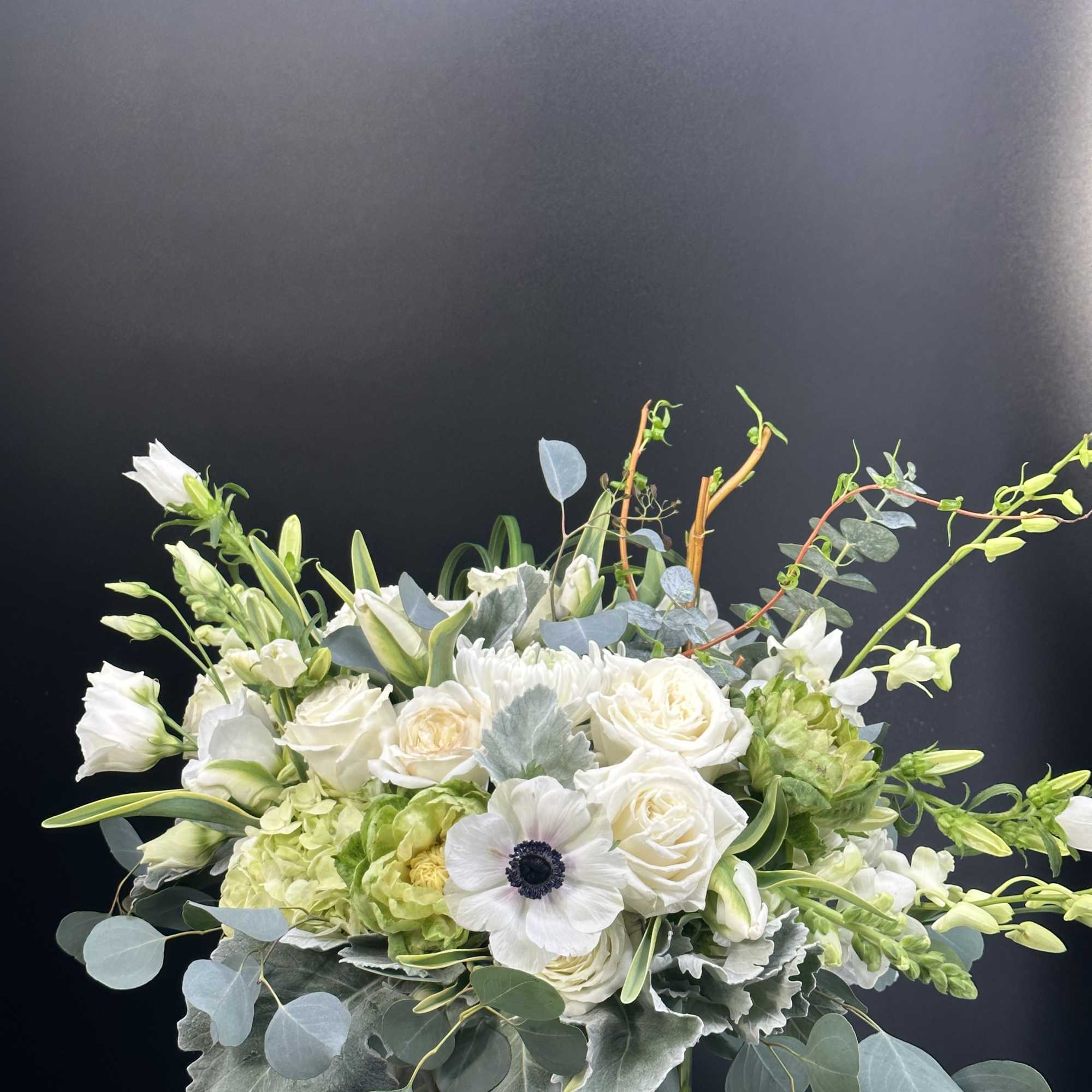 White and green floral arrangement in a clear glass vase