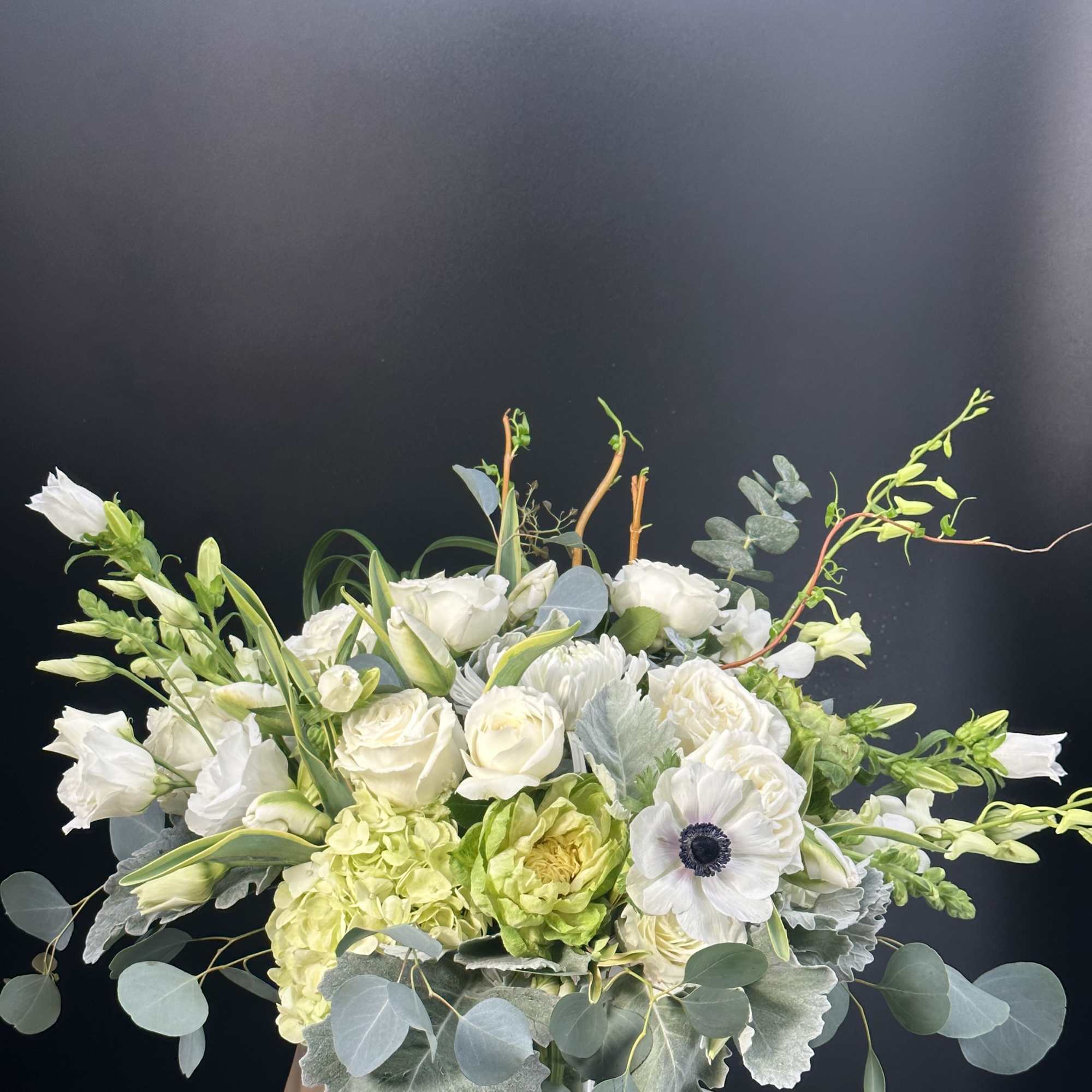 White and pale green floral arrangement in a glass vase