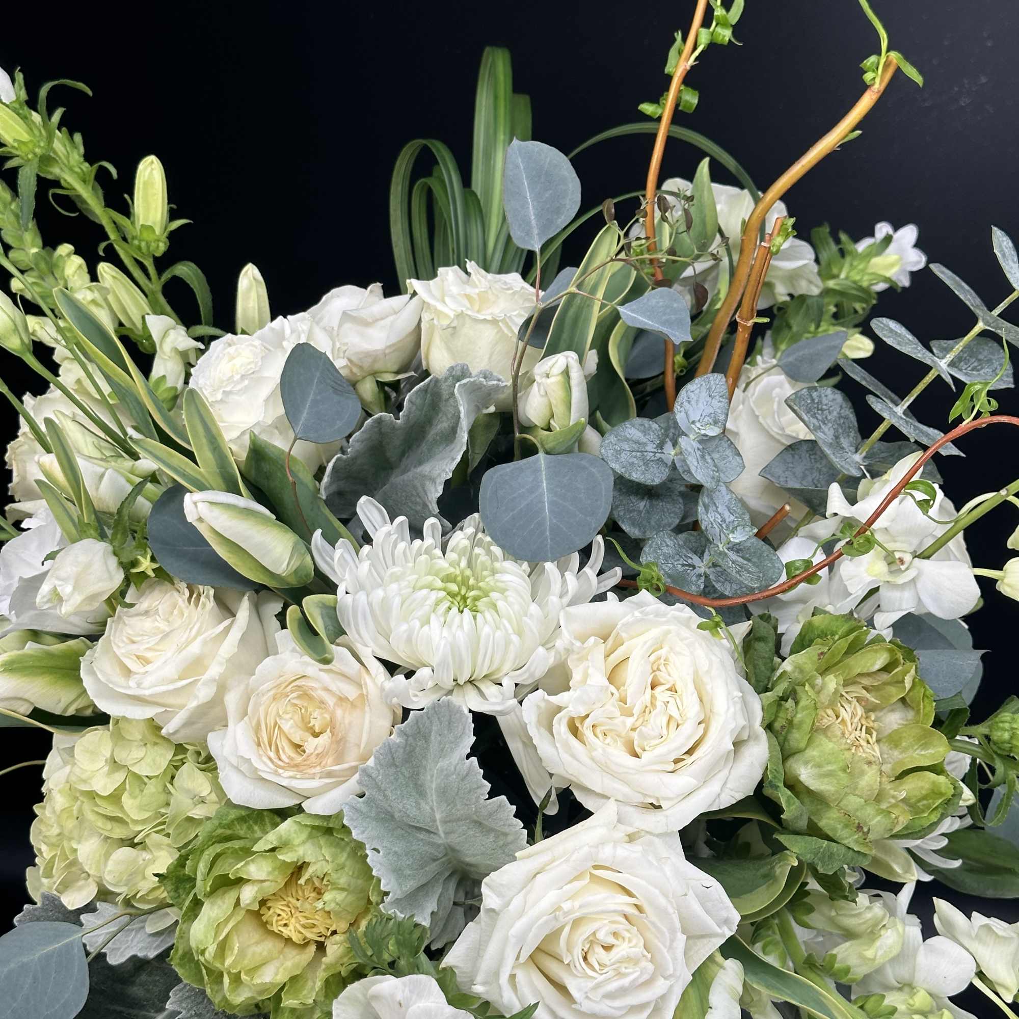 White roses and anemones with eucalyptus in a loose bouquet