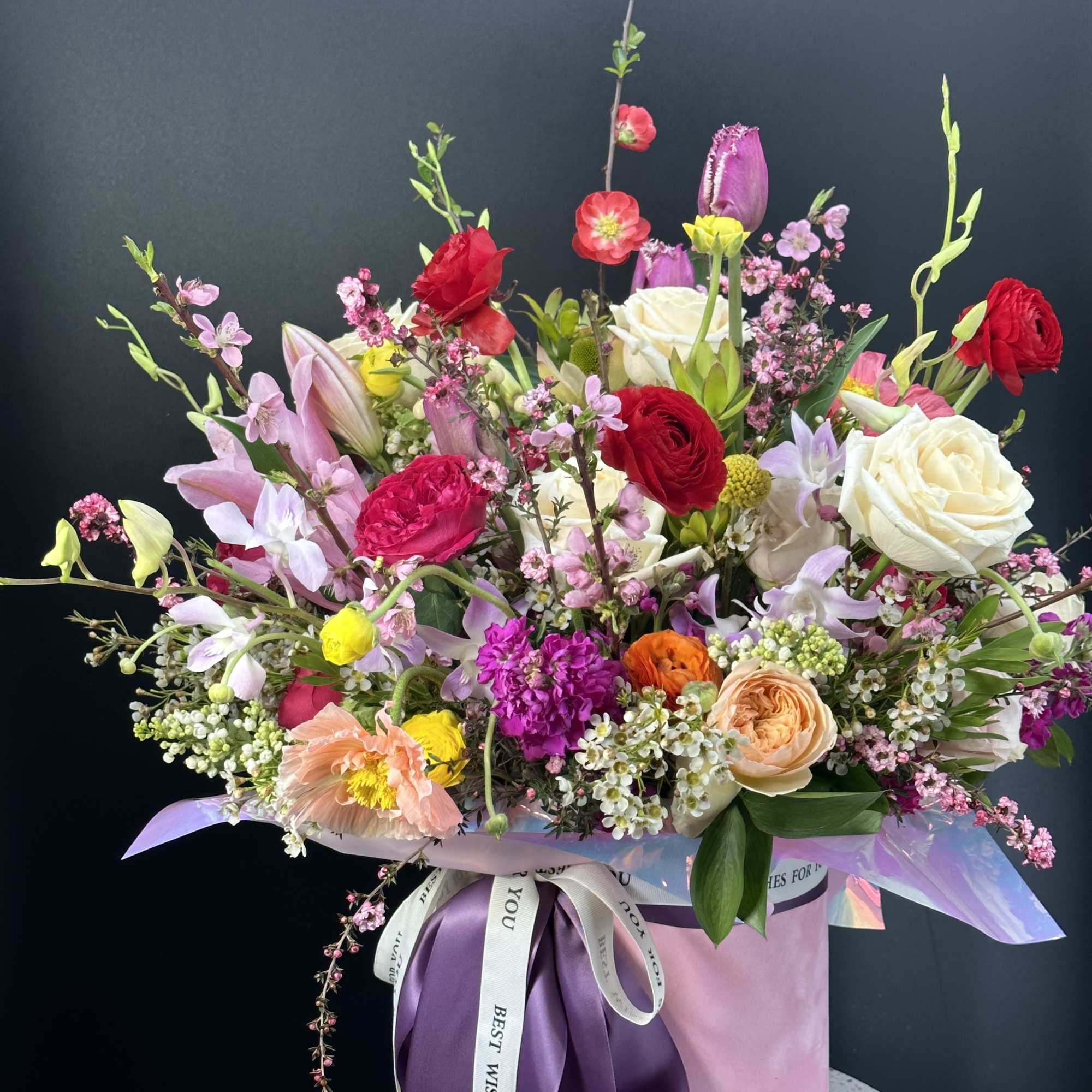 Large mixed bouquet in a pink hatbox with purple ribbon
