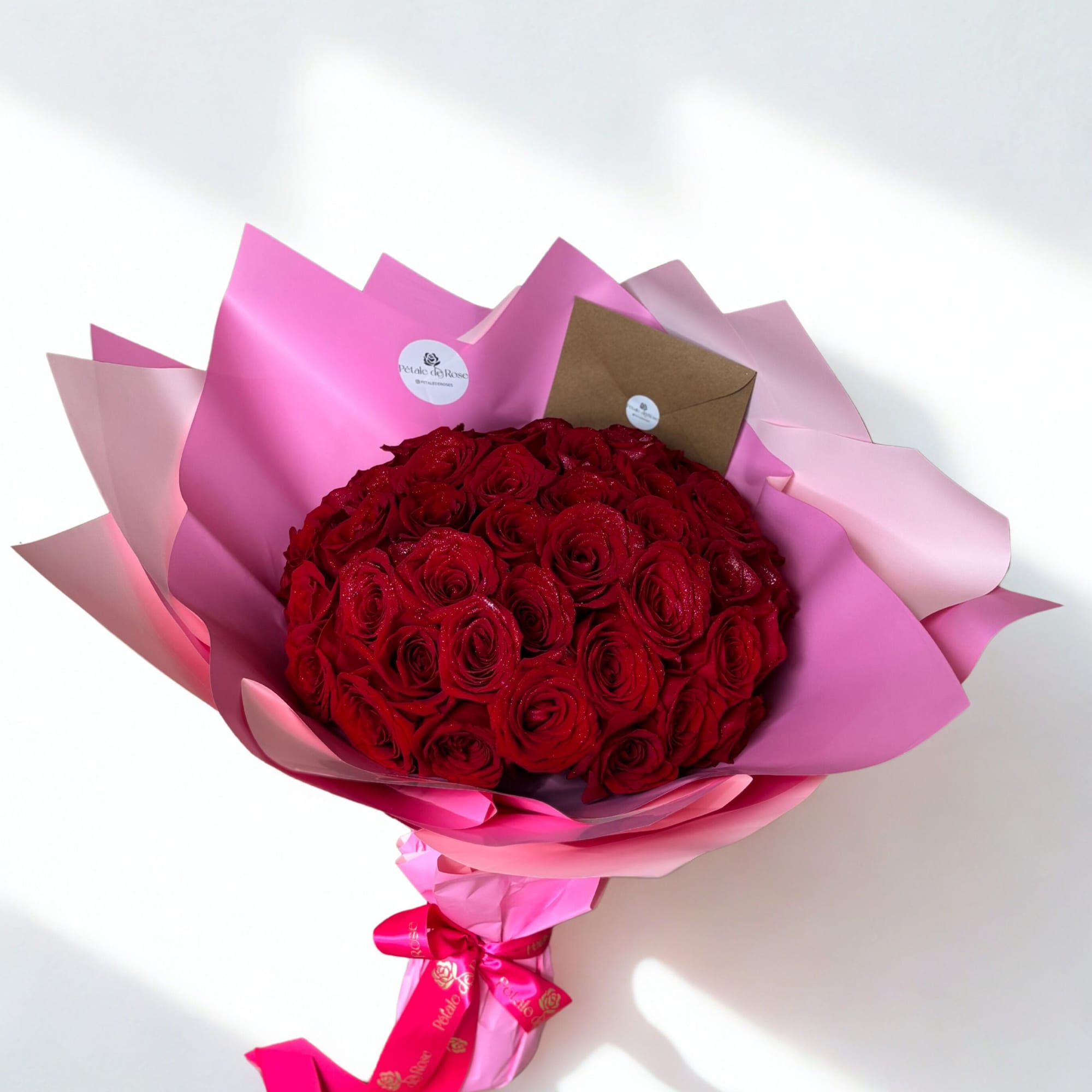 Red roses wrapped in pink wrapping paper

 Handcrafted with love by P&eacute;tale