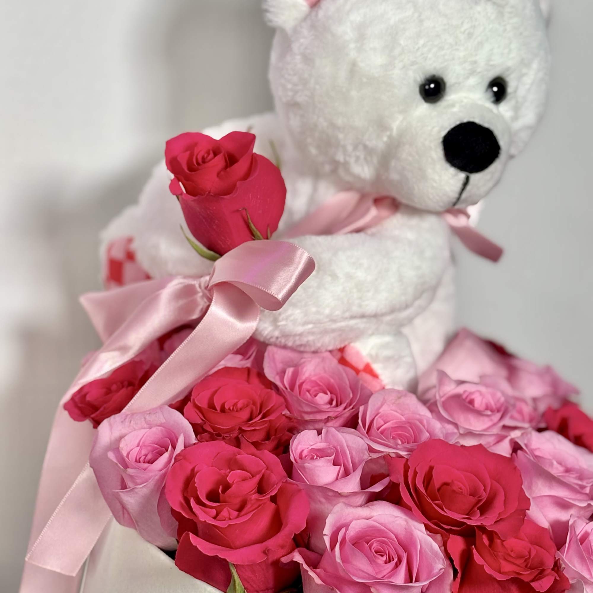 White teddy bear with pink roses and ribbon