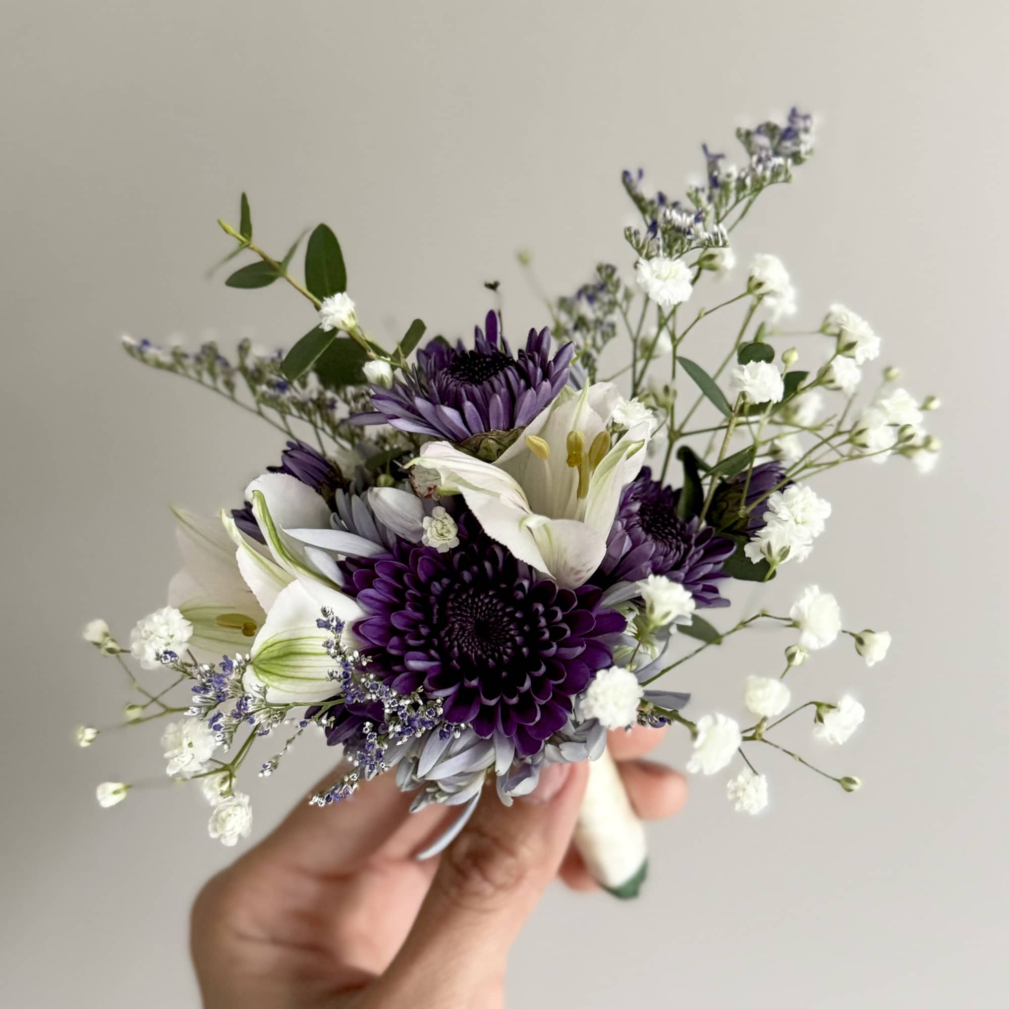 Small hand-tied bouquet of purple and white flowers