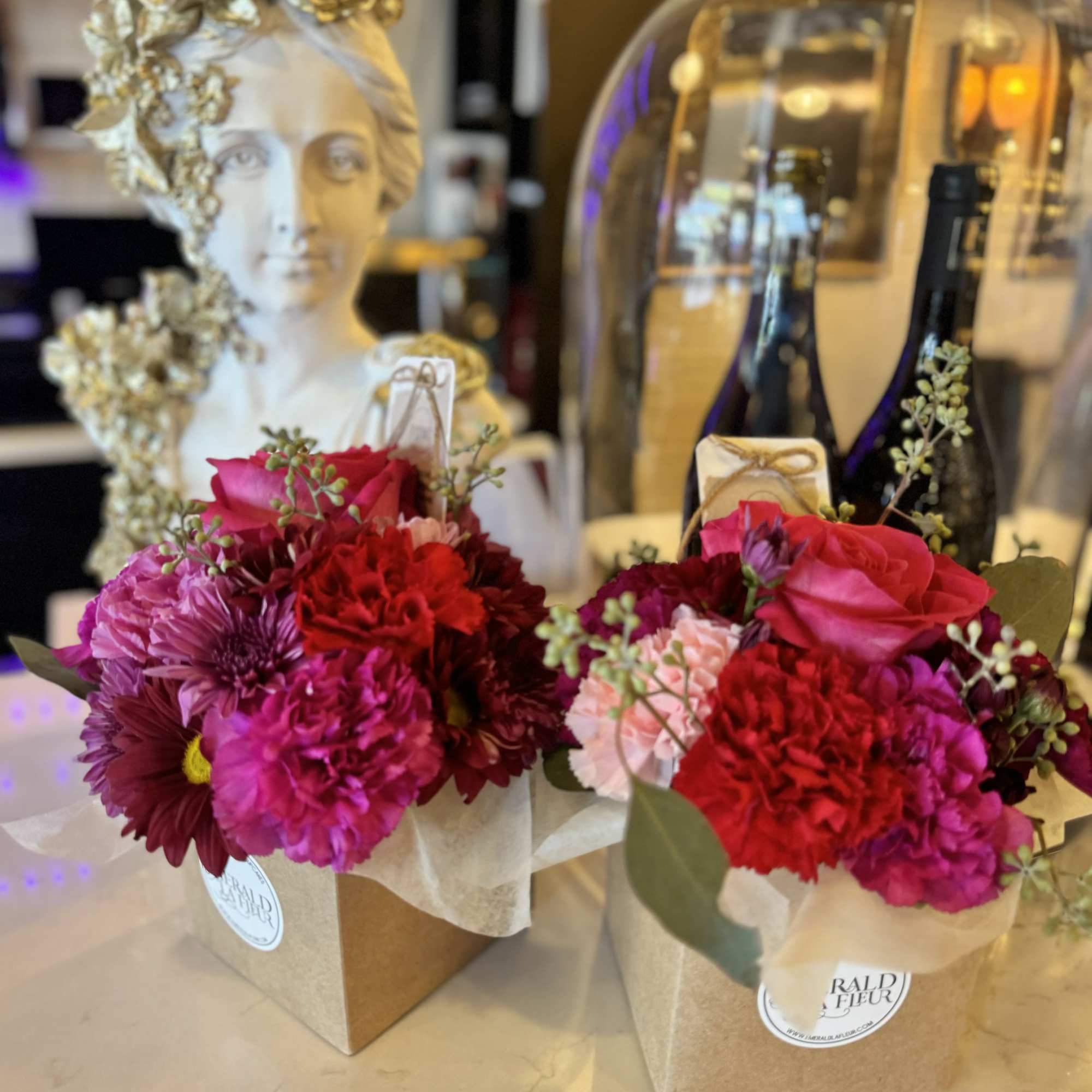 Two small boxed bouquets of pink and red flowers