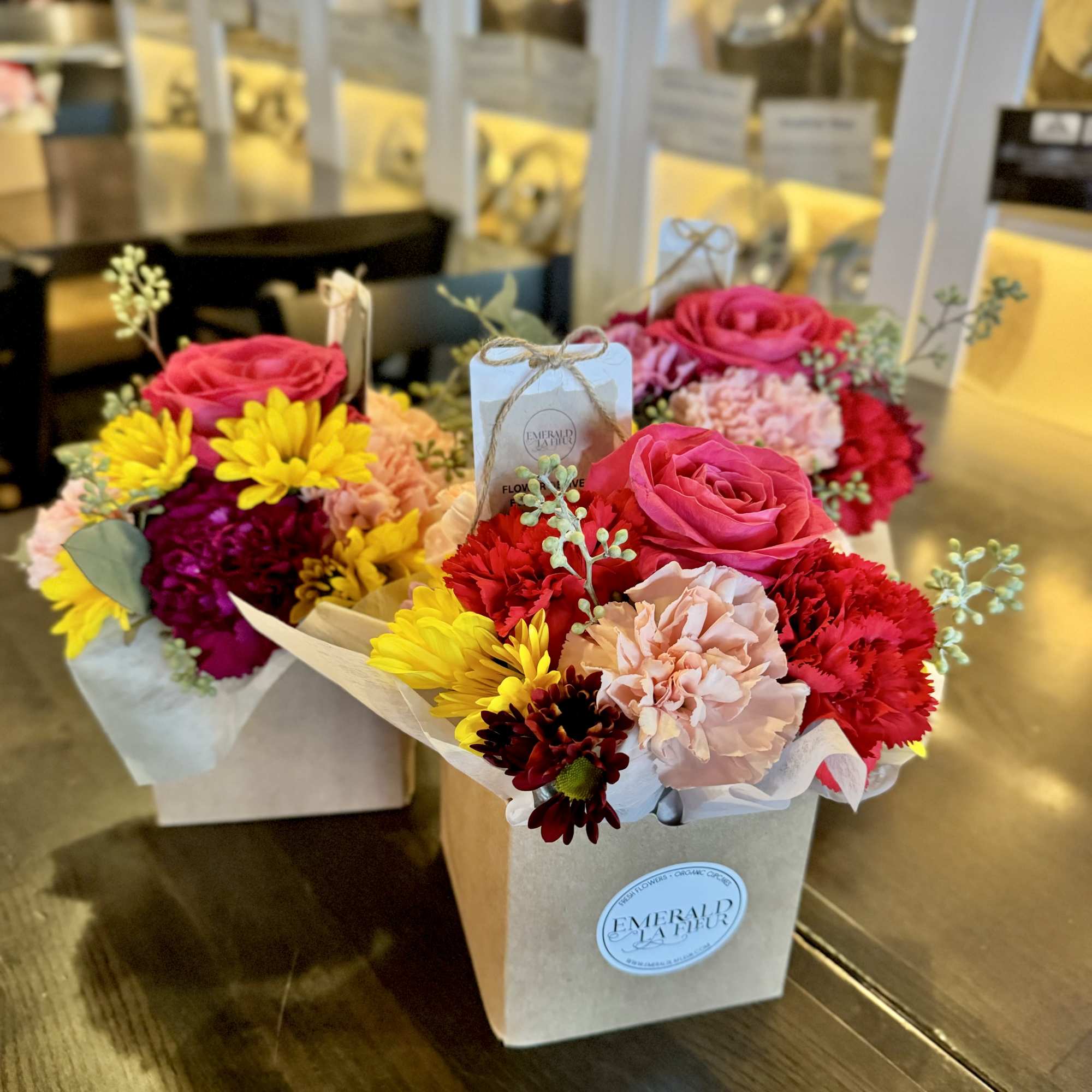 Two small boxed bouquets with pink roses and mixed flowers