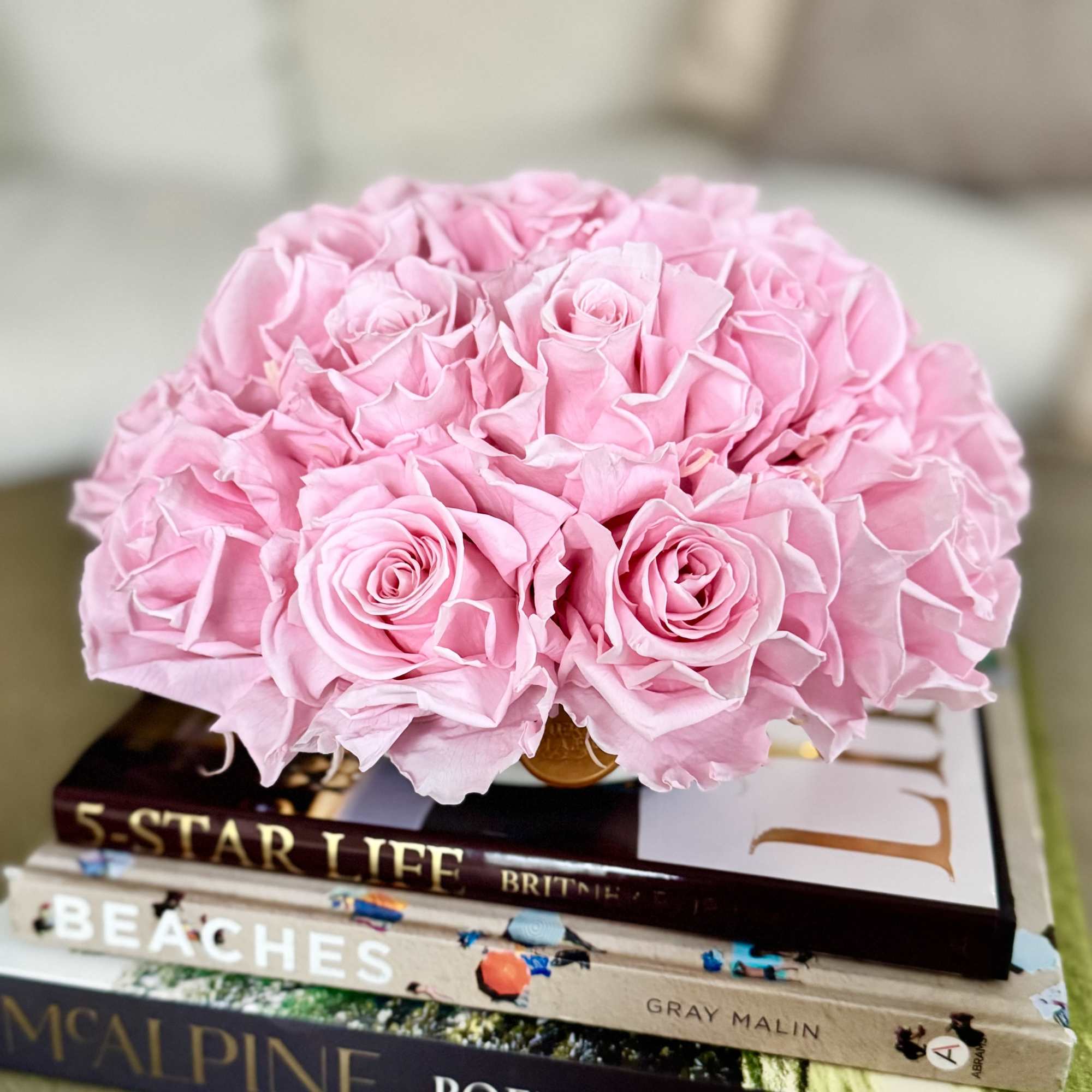 Pink rose bouquet resting on a stack of books