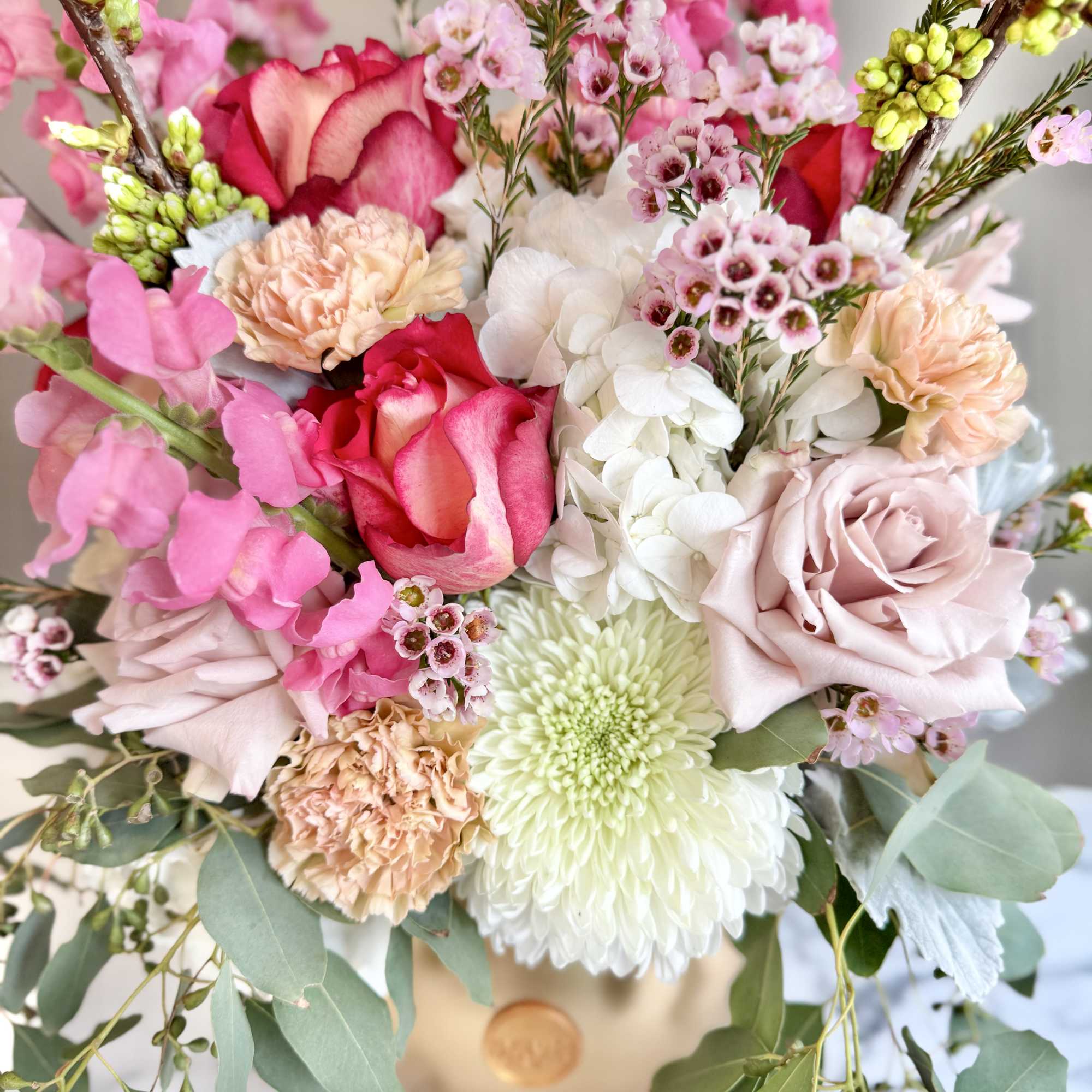 Bouquet of pink and white flowers in a gold box