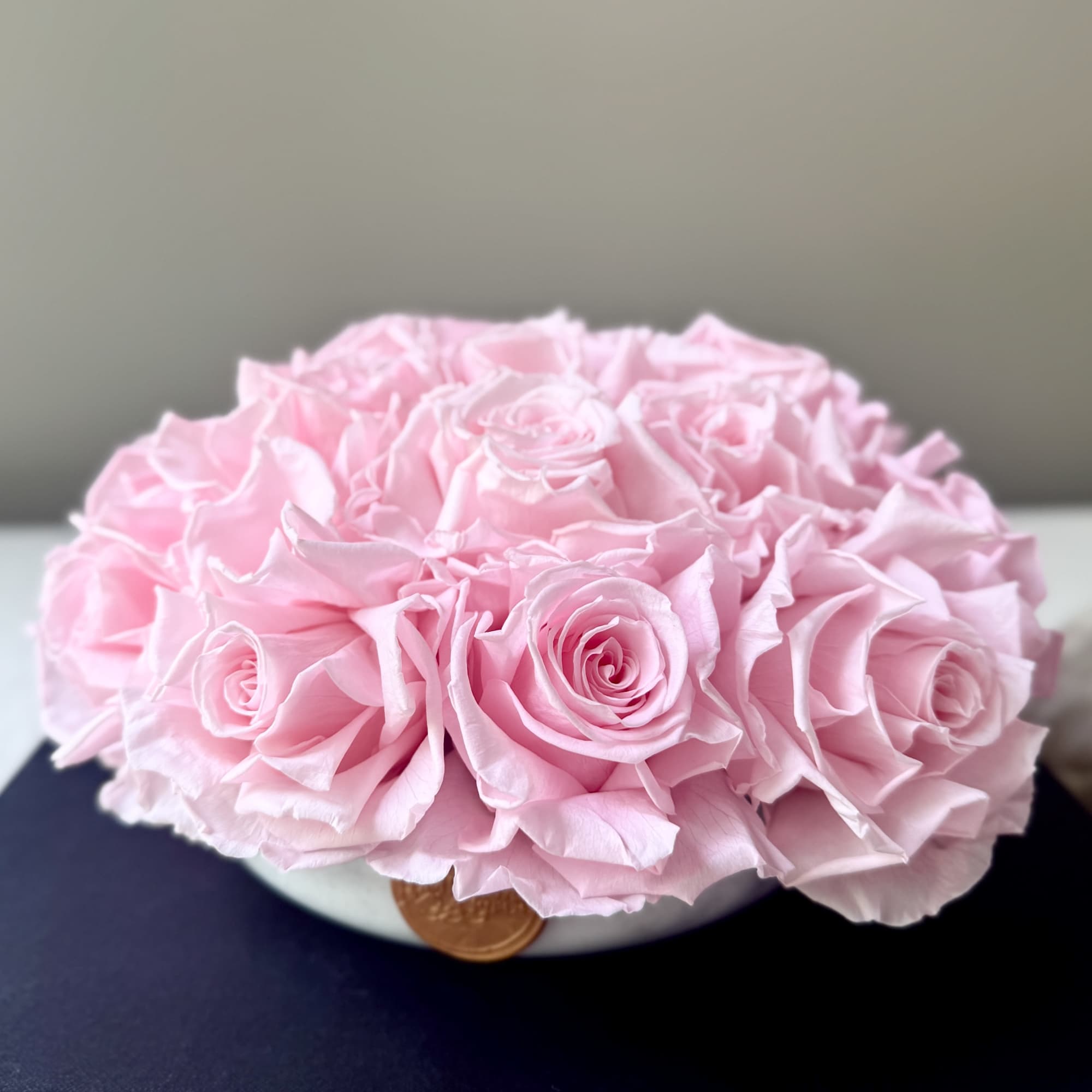 Pink rose bouquet in a low white container