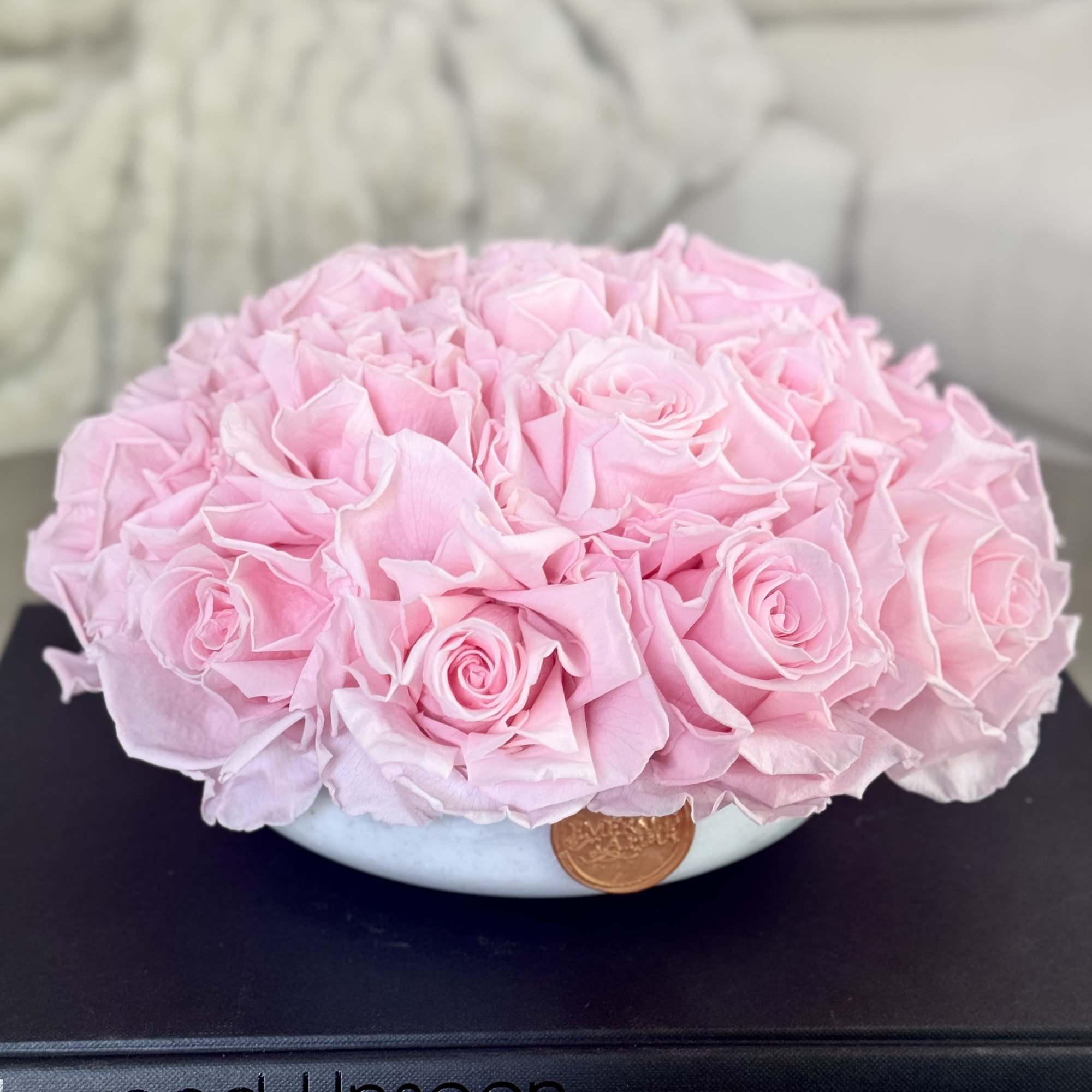 Round bouquet of pale pink roses in a low white bowl