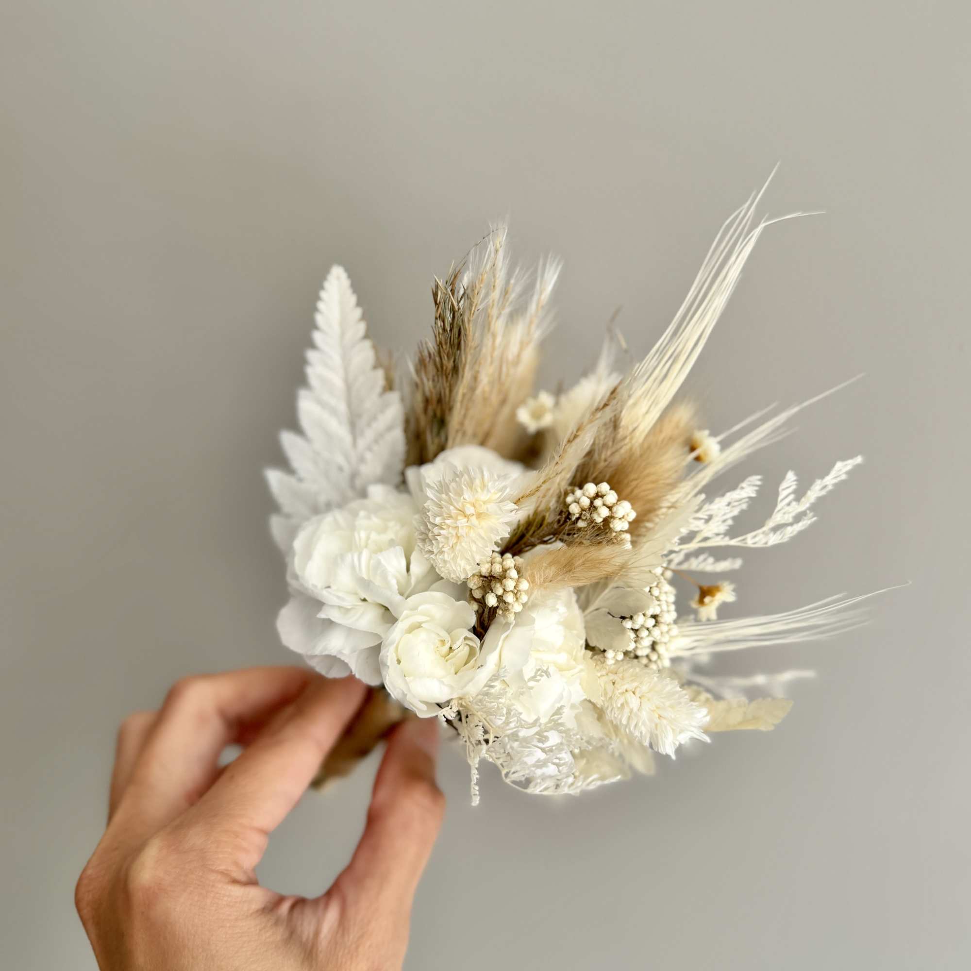 Small white dried flower bouquet held in a hand