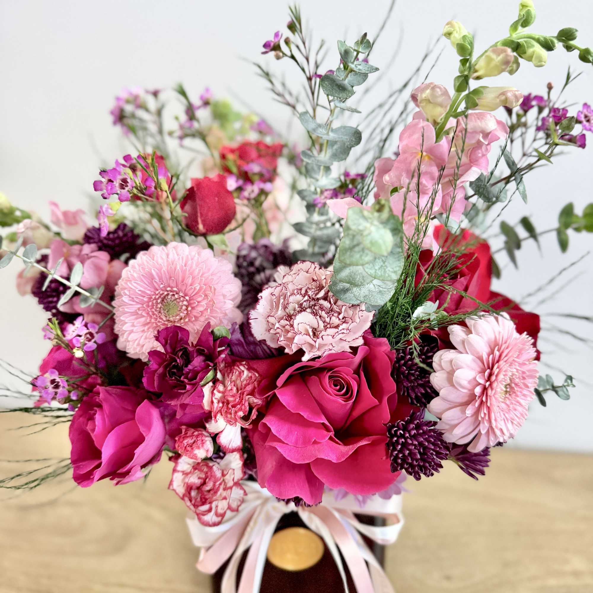 Pink and red mixed bouquet in a vase with ribbon