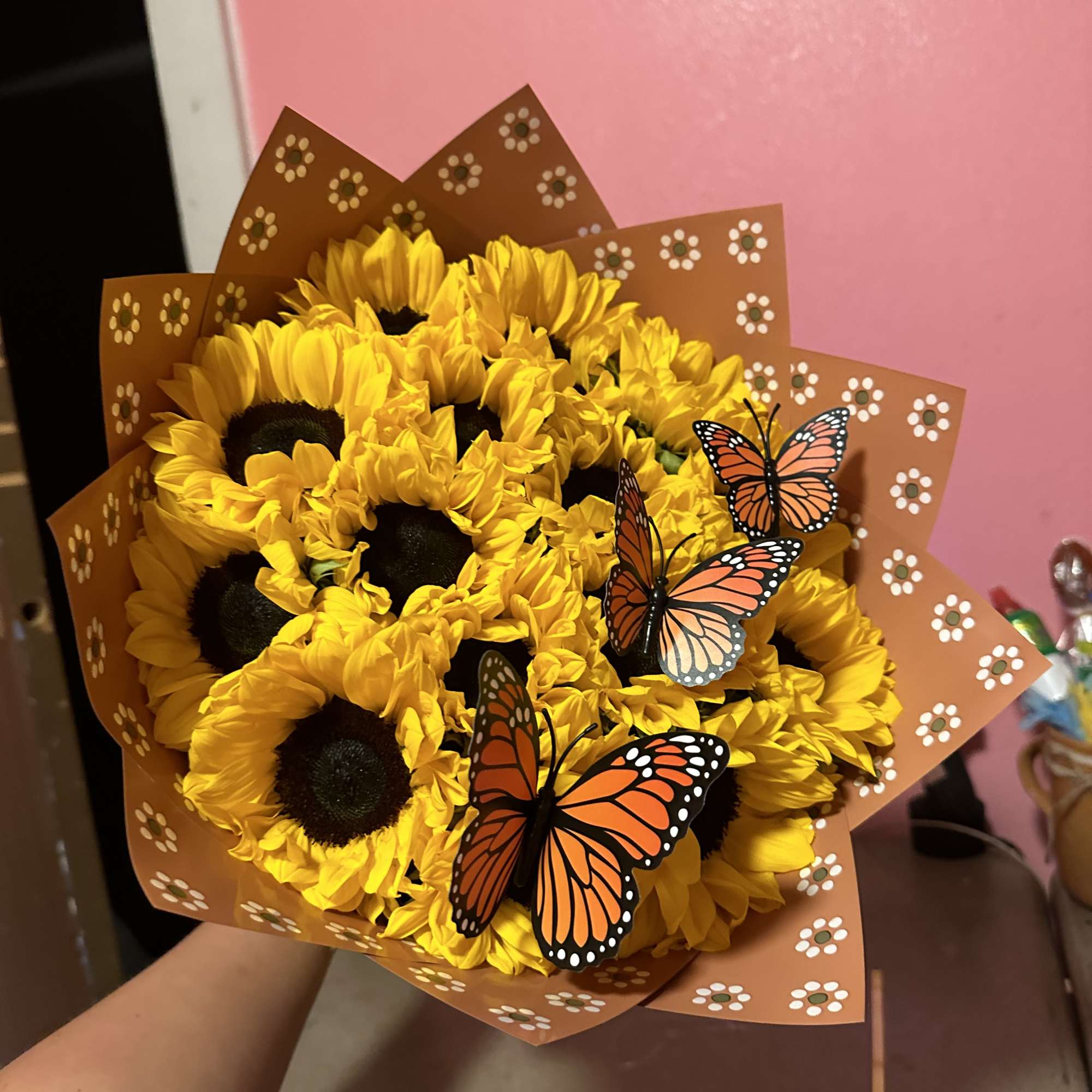 Bouquet of yellow sunflowers wrapped in brown paper with butterfly decorations