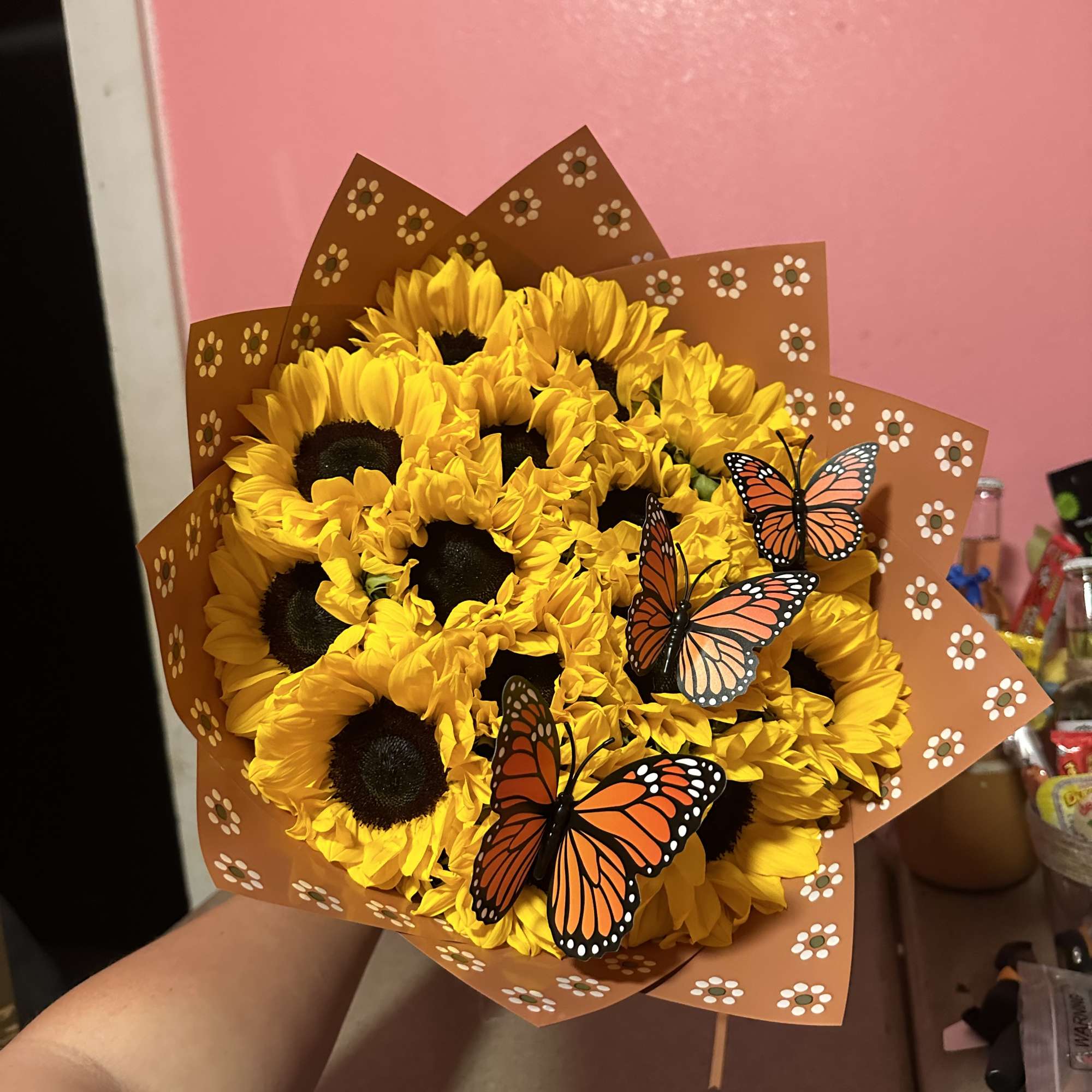 Bouquet of yellow sunflowers with butterfly decorations in brown wrap