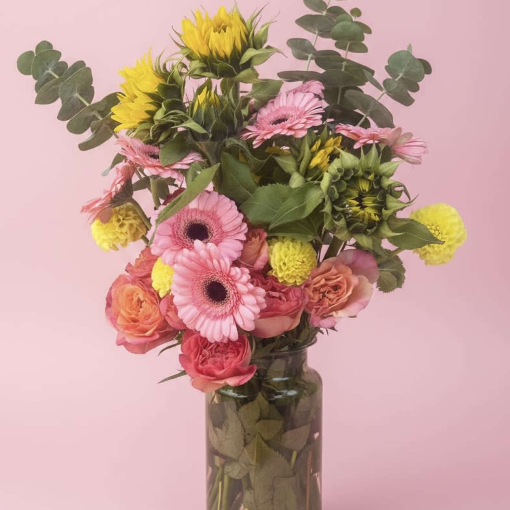 A burst of sherbet colors-peachy-pink gerbera daisies, coral and pink roses, and