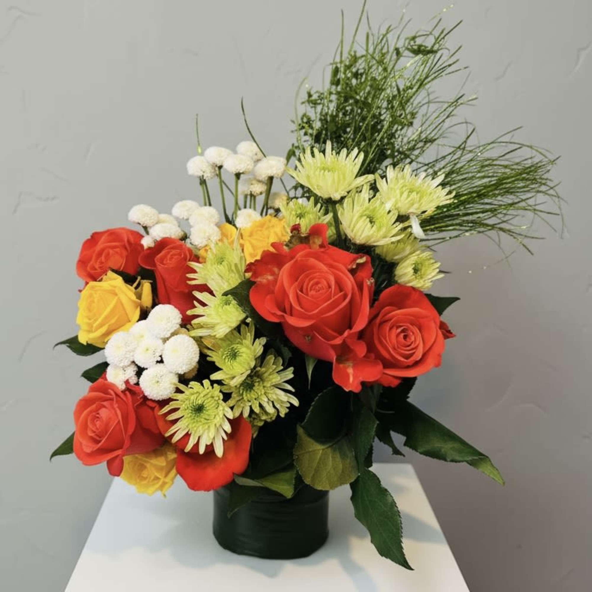 Bright clusters of red and yellow roses meet pale green daisy mums