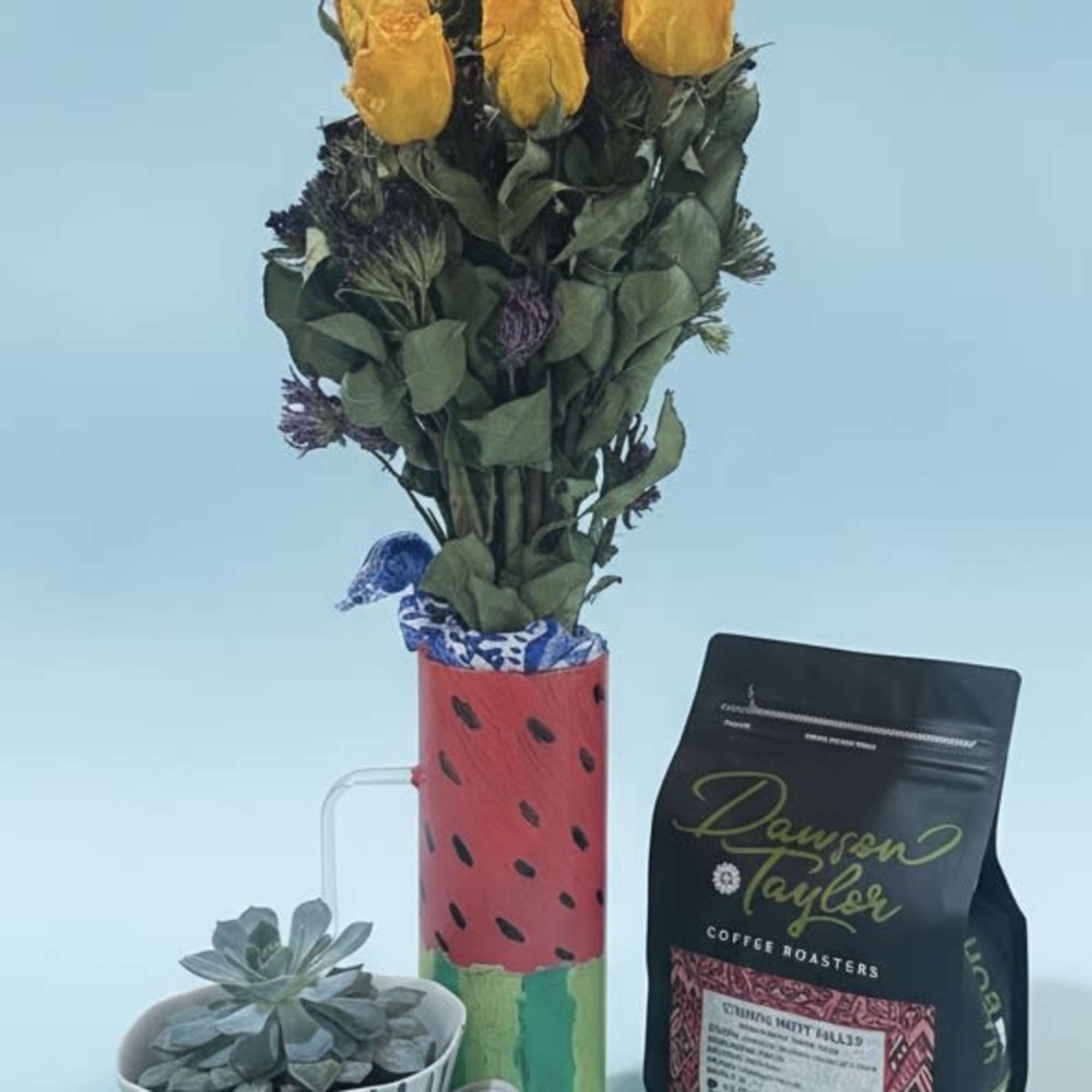 Bright, cheerful yellow roses paired with a compact succulent create a playful