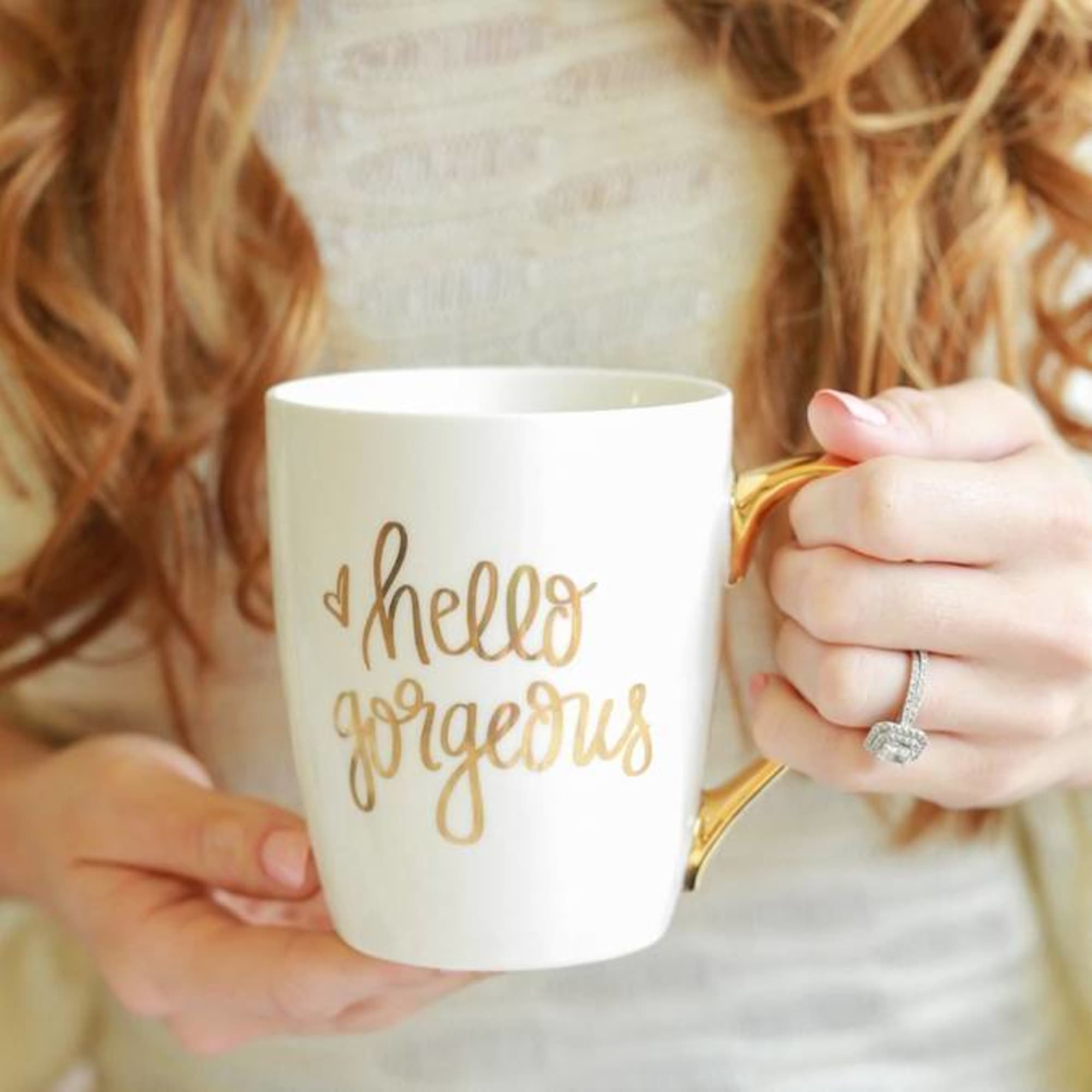 White mug with gold handle and "hello gorgeous" text