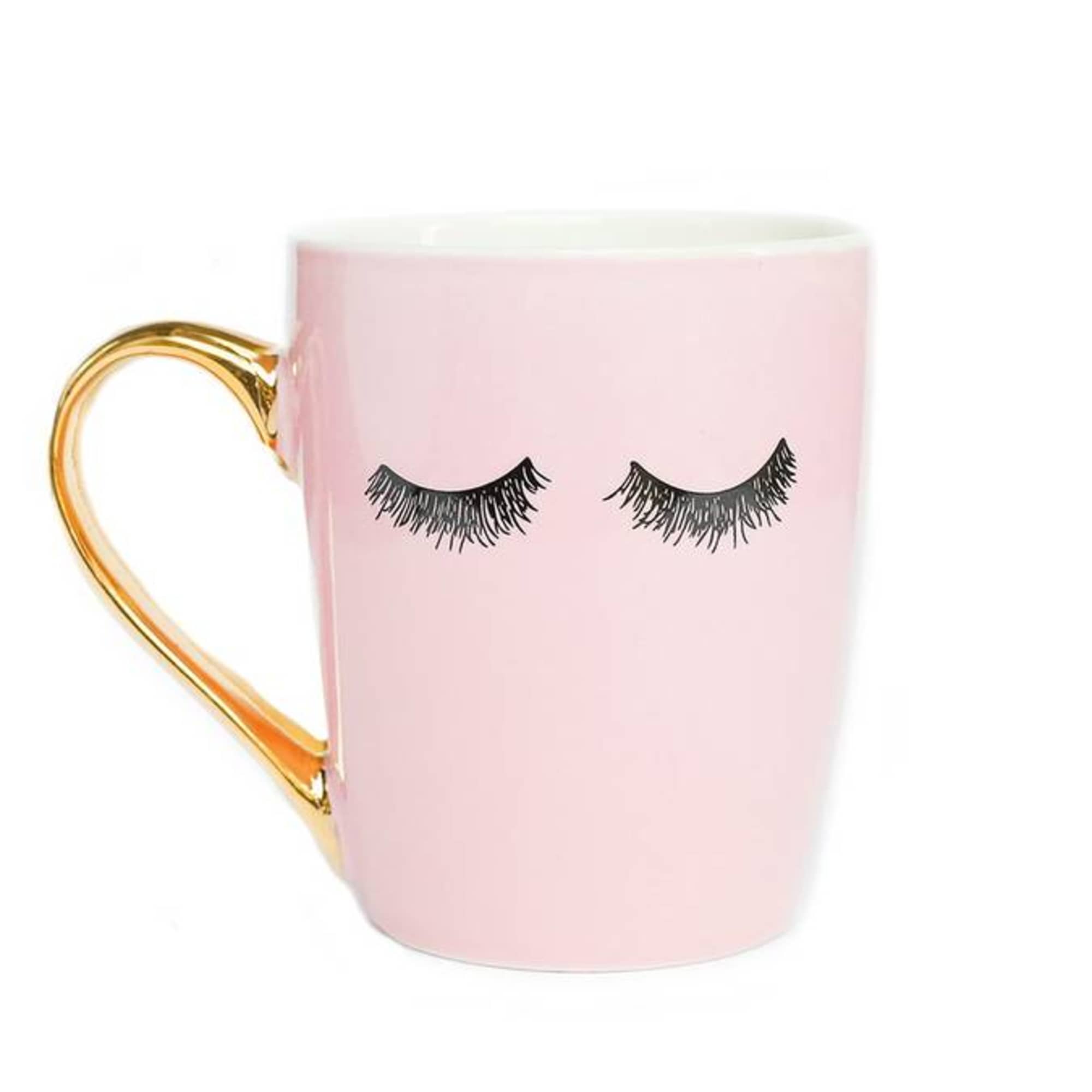 Pink mug with closed eyelash design and gold handle