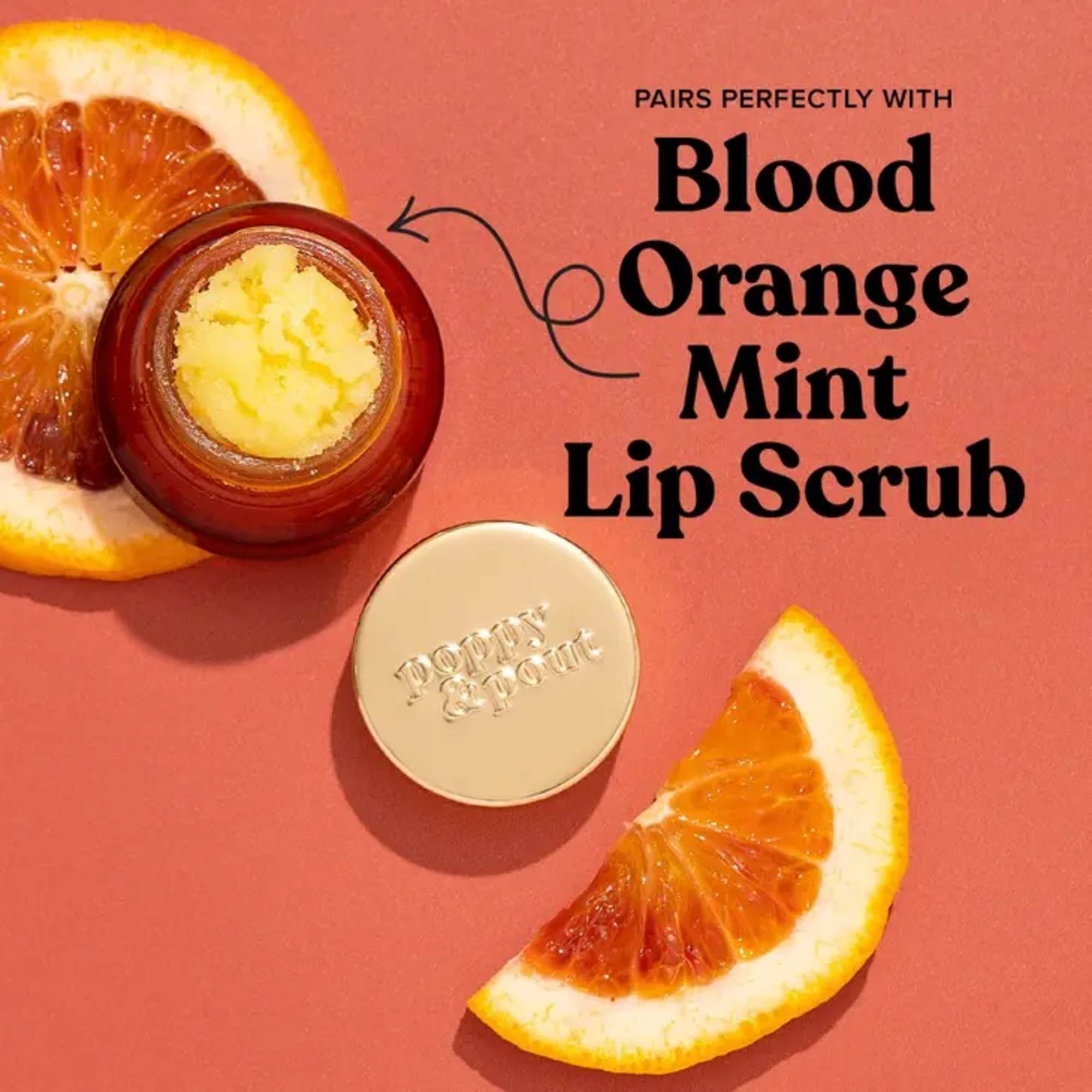 Open jar of lip scrub with orange slices on a pink background