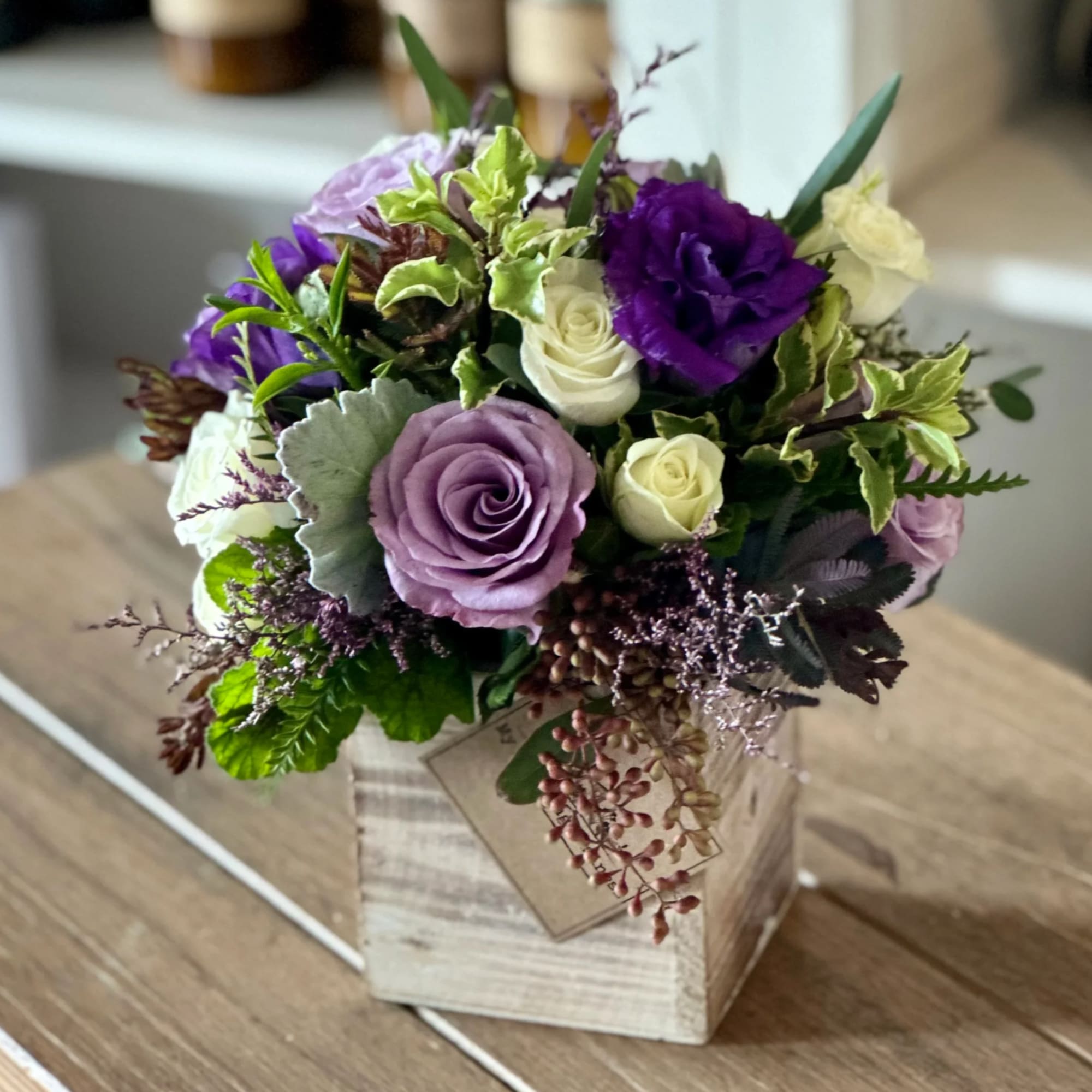 Purple and white rose bouquet in a wooden box