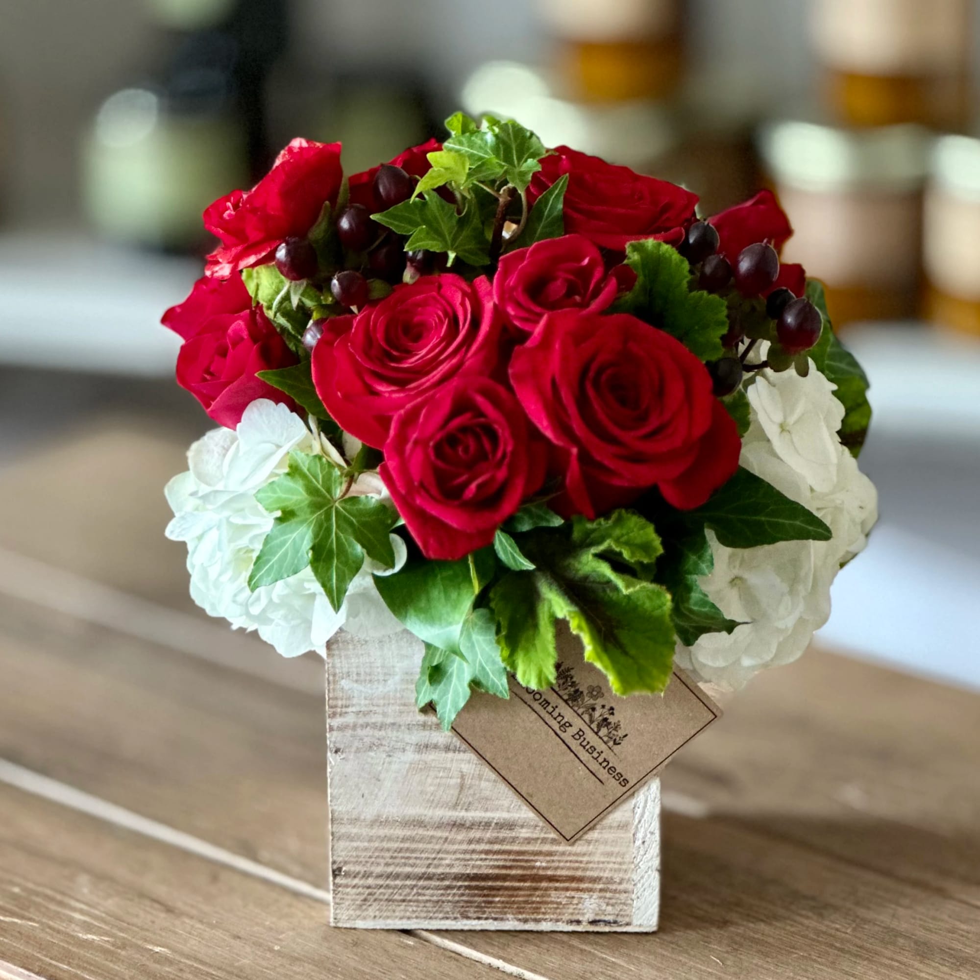 Red roses and white hydrangeas in a rustic wooden box