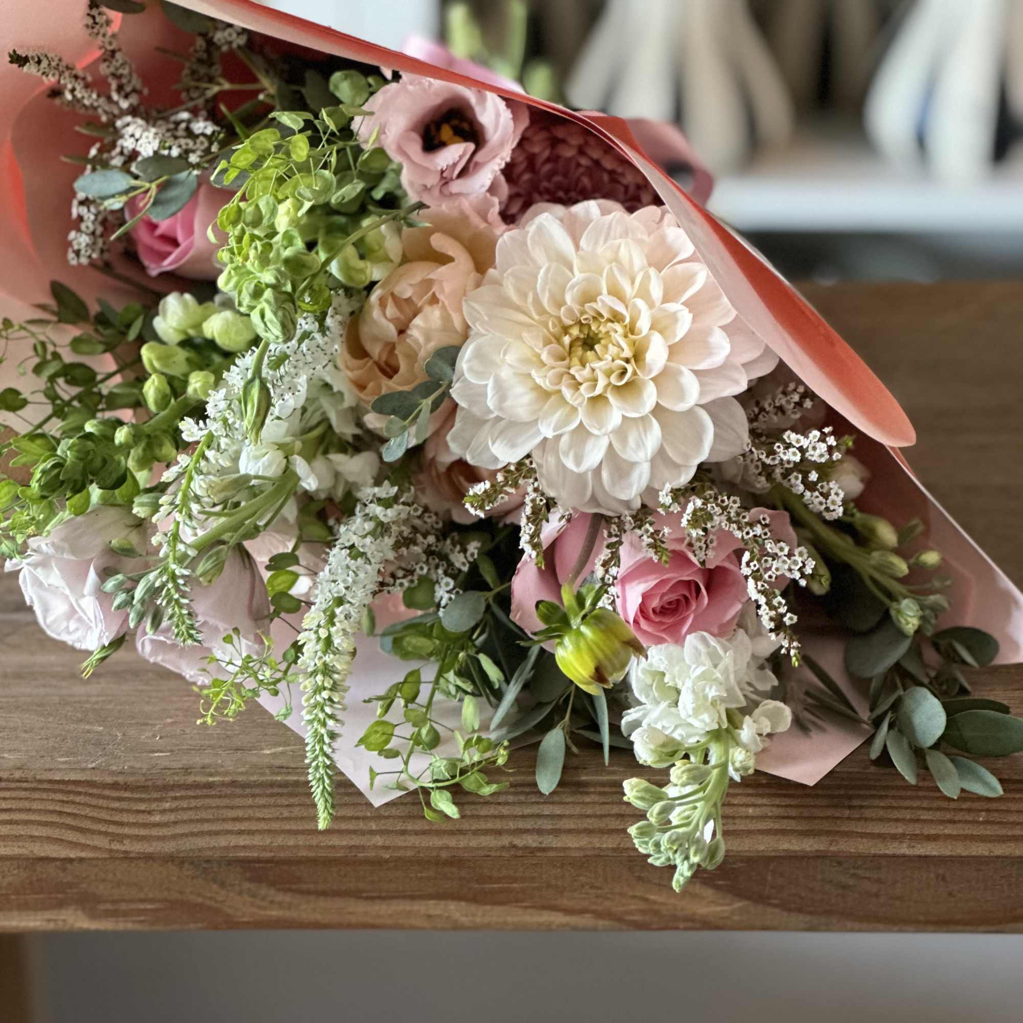 Pink and white mixed bouquet wrapped in coral paper