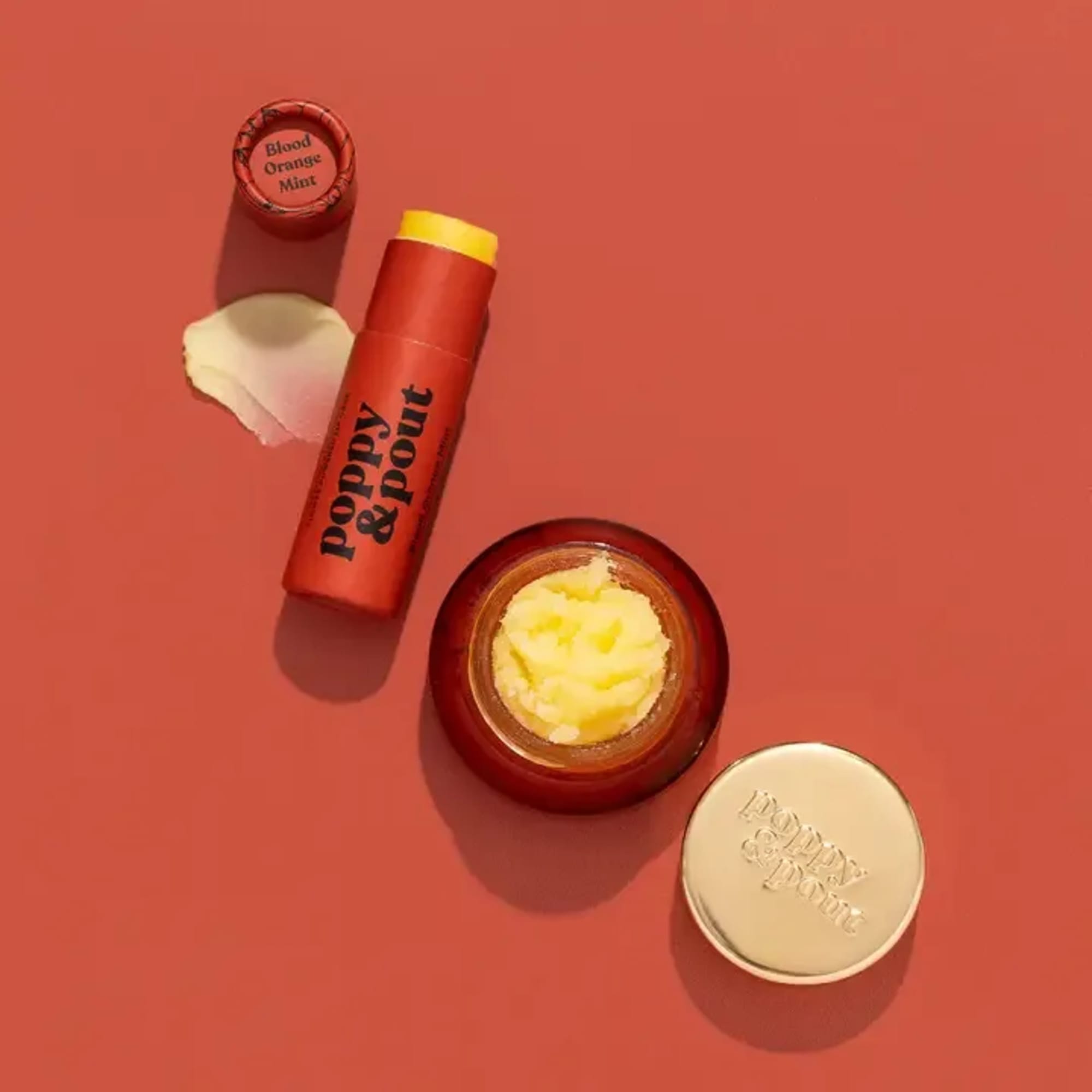 Lip balm tubes and tins on a coral background