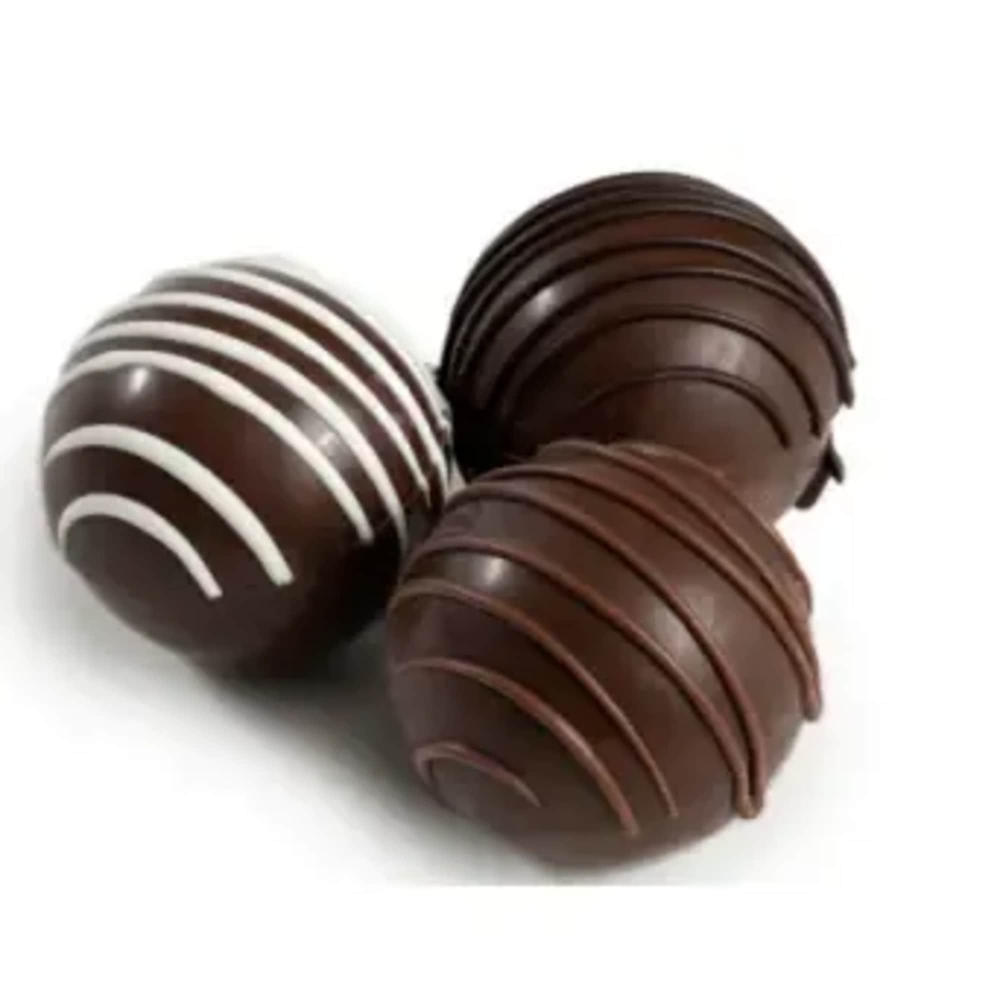 Three chocolate truffles with striped drizzle on a white background