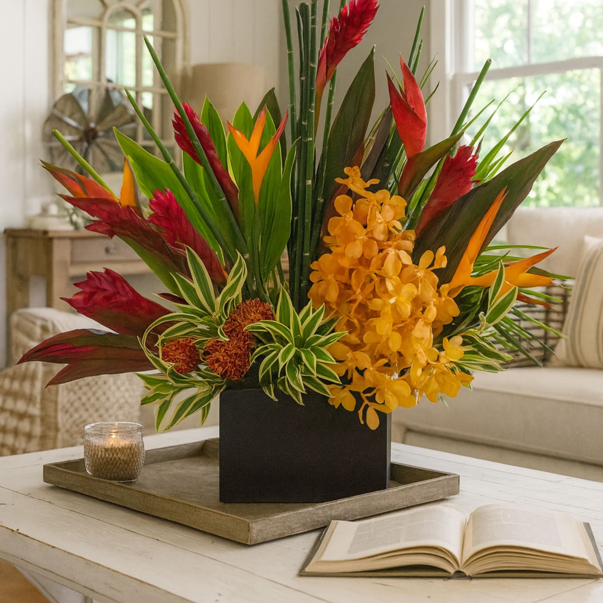 Tropical floral arrangement in a black rectangular vase on a tray
