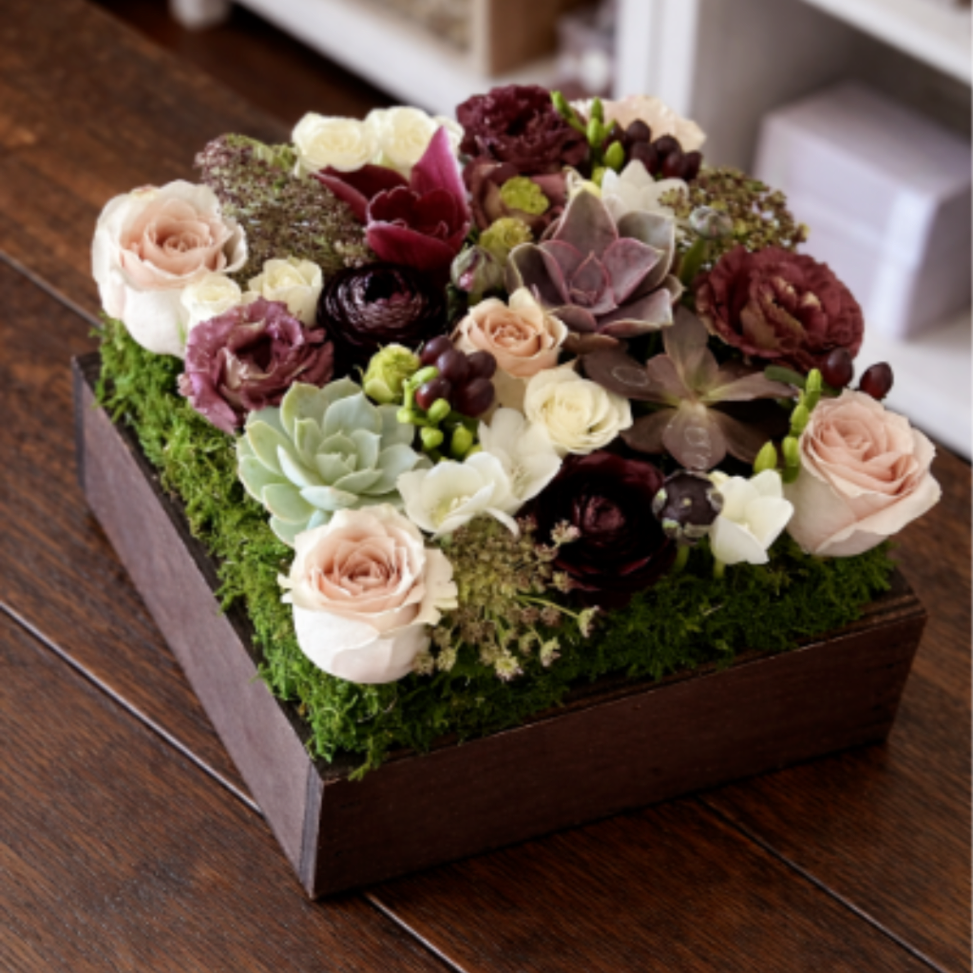 Succulent and rose arrangement in a wooden box