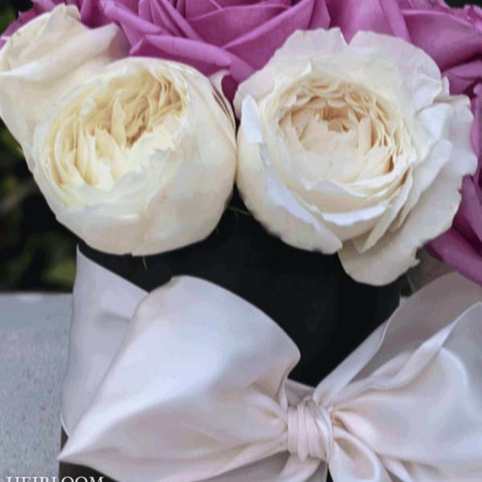 Bouquet of lavender and white roses tied with a white satin bow