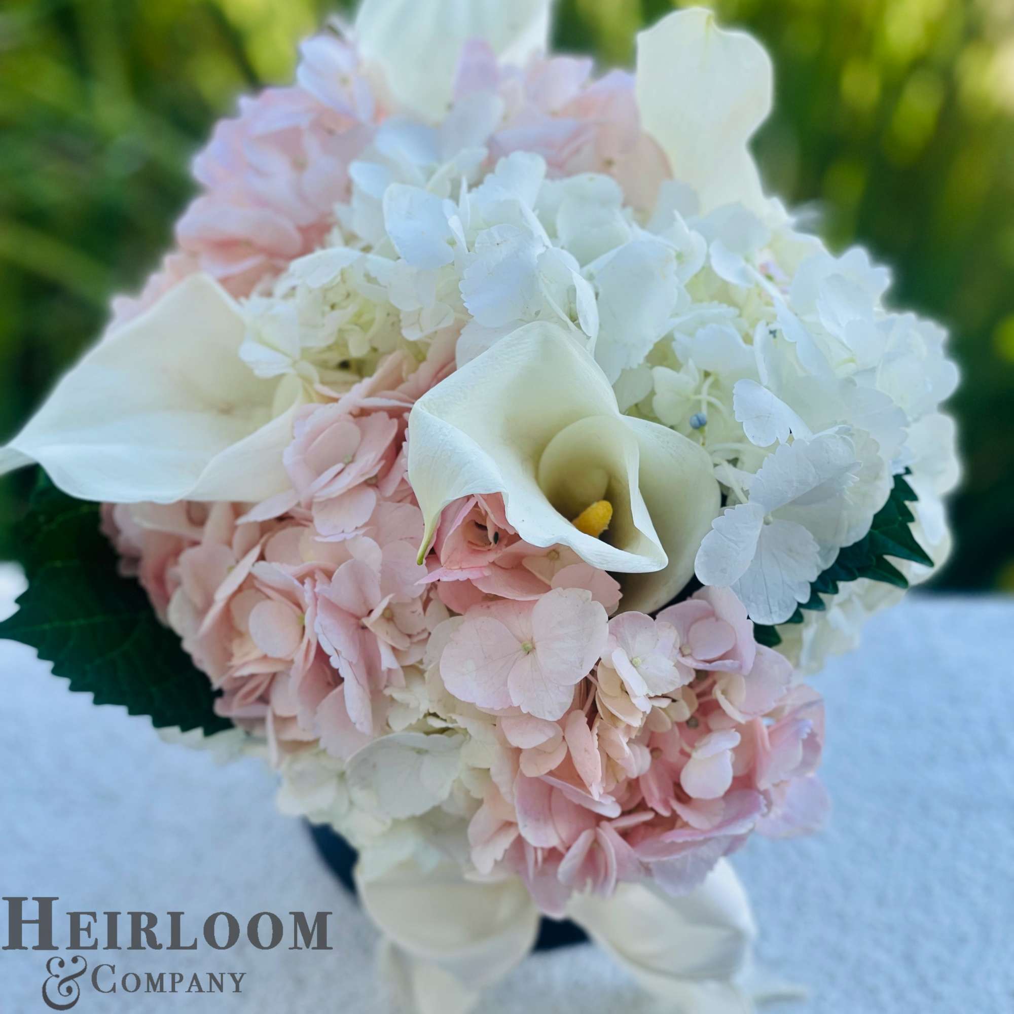 White calla lilies and pale pink hydrangeas in a bouquet