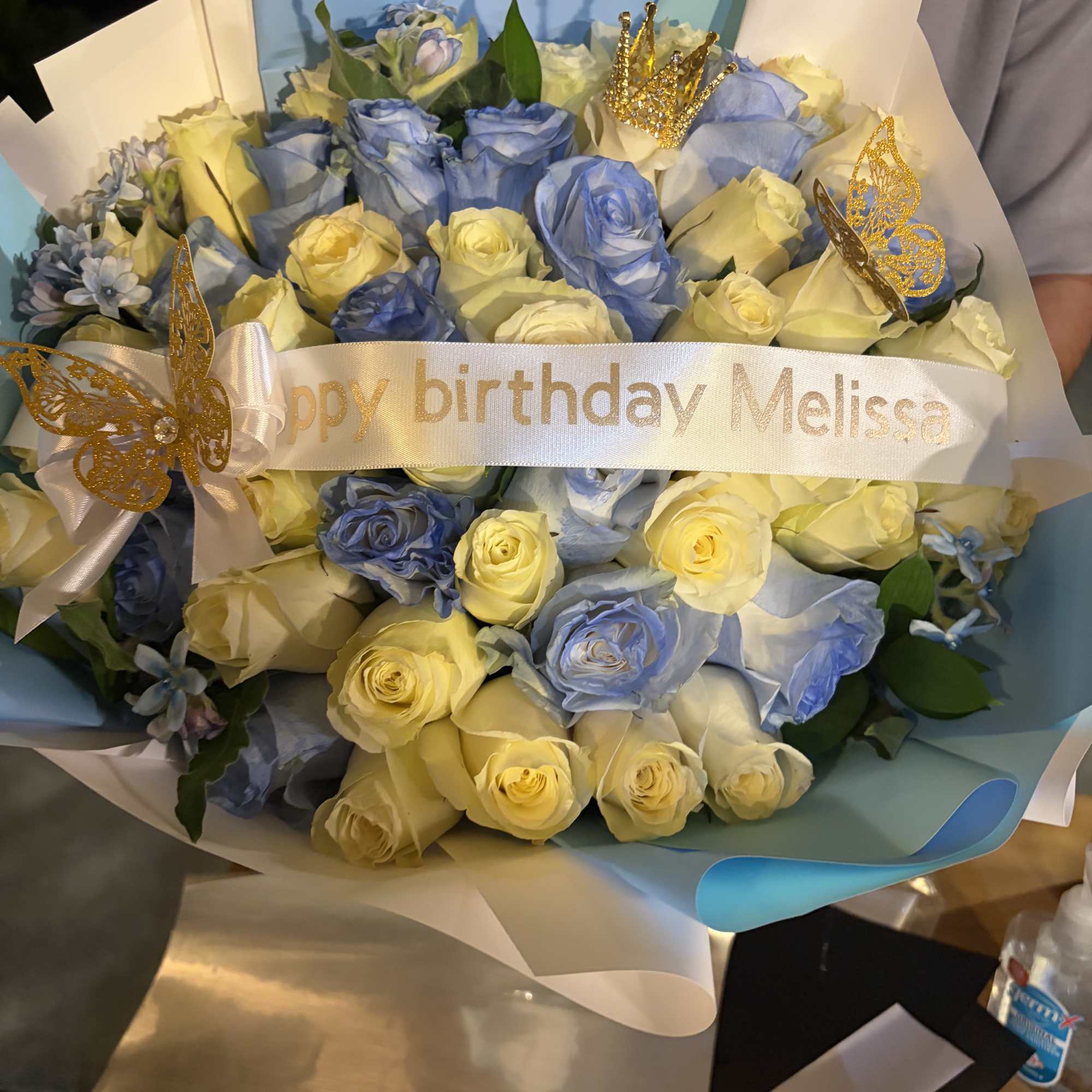 Bouquet of blue and cream roses with a birthday ribbon