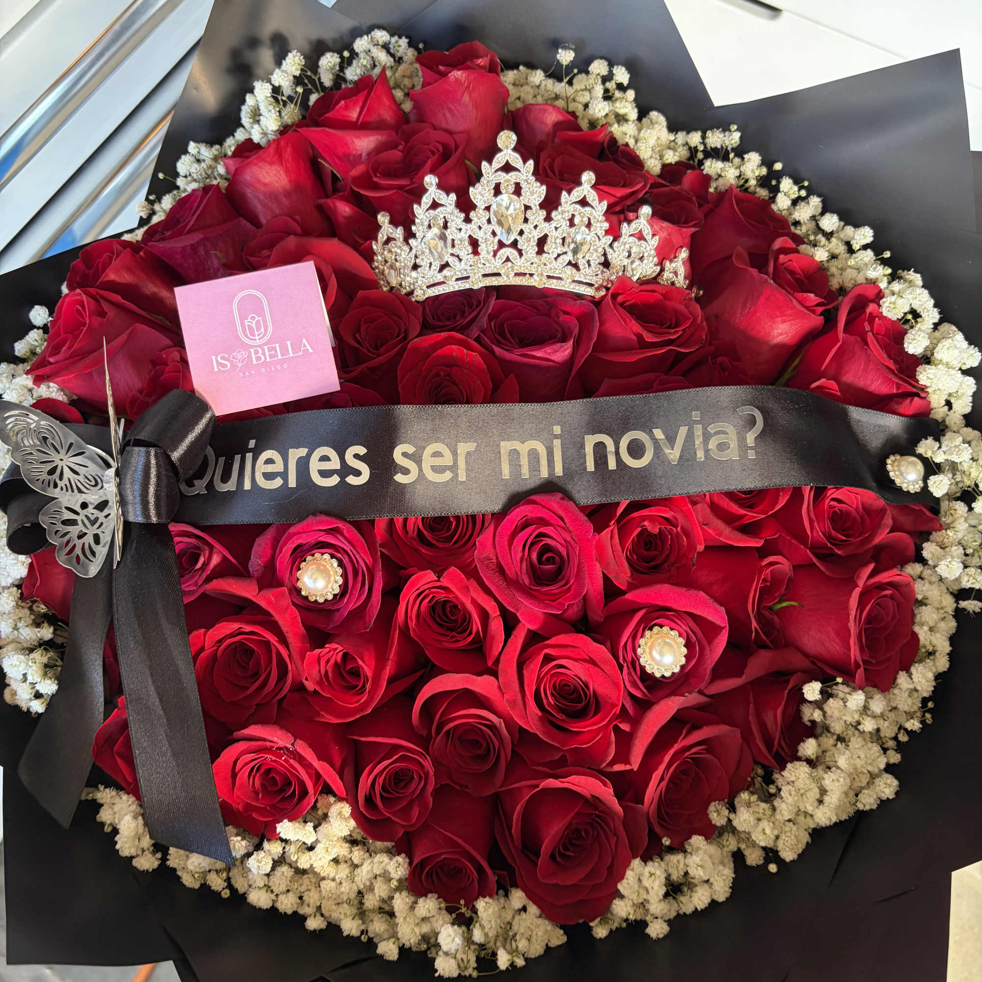 Bouquet of red roses with a black ribbon and crown decoration
