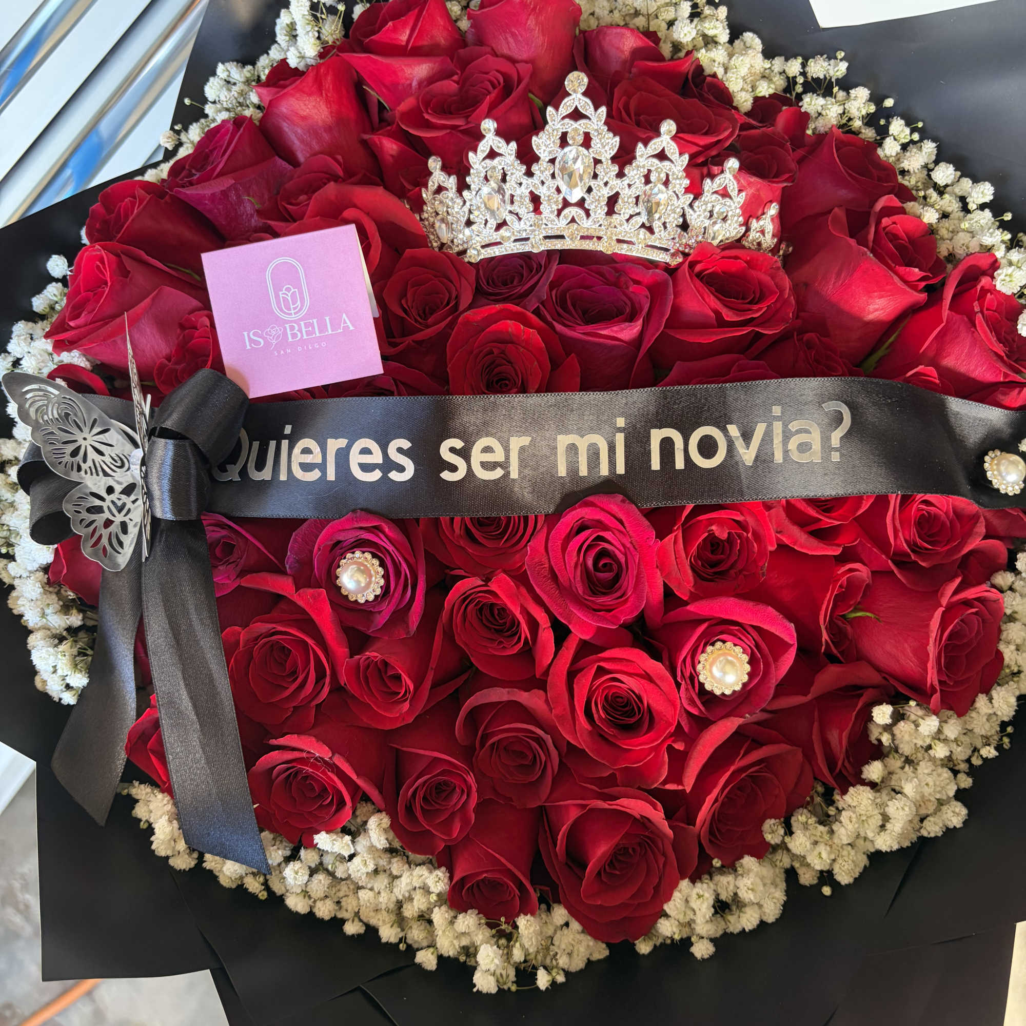 Red rose bouquet with baby's breath, black wrap, and a decorative crown