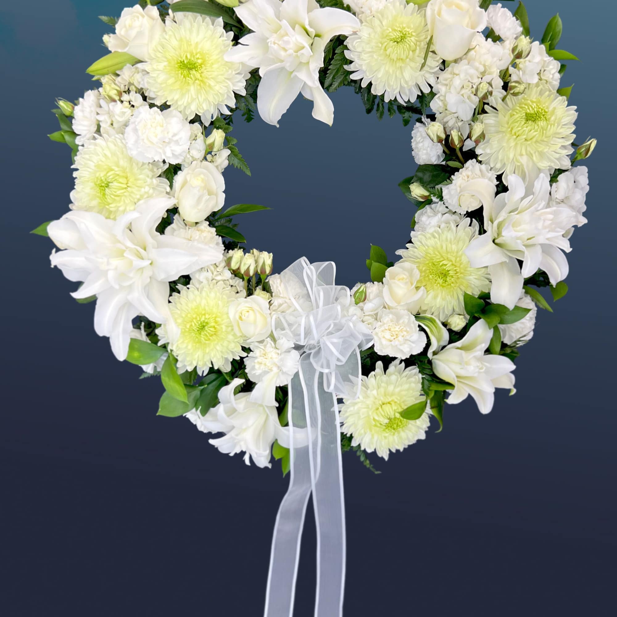 Heart-shaped white floral wreath with a ribbon bow