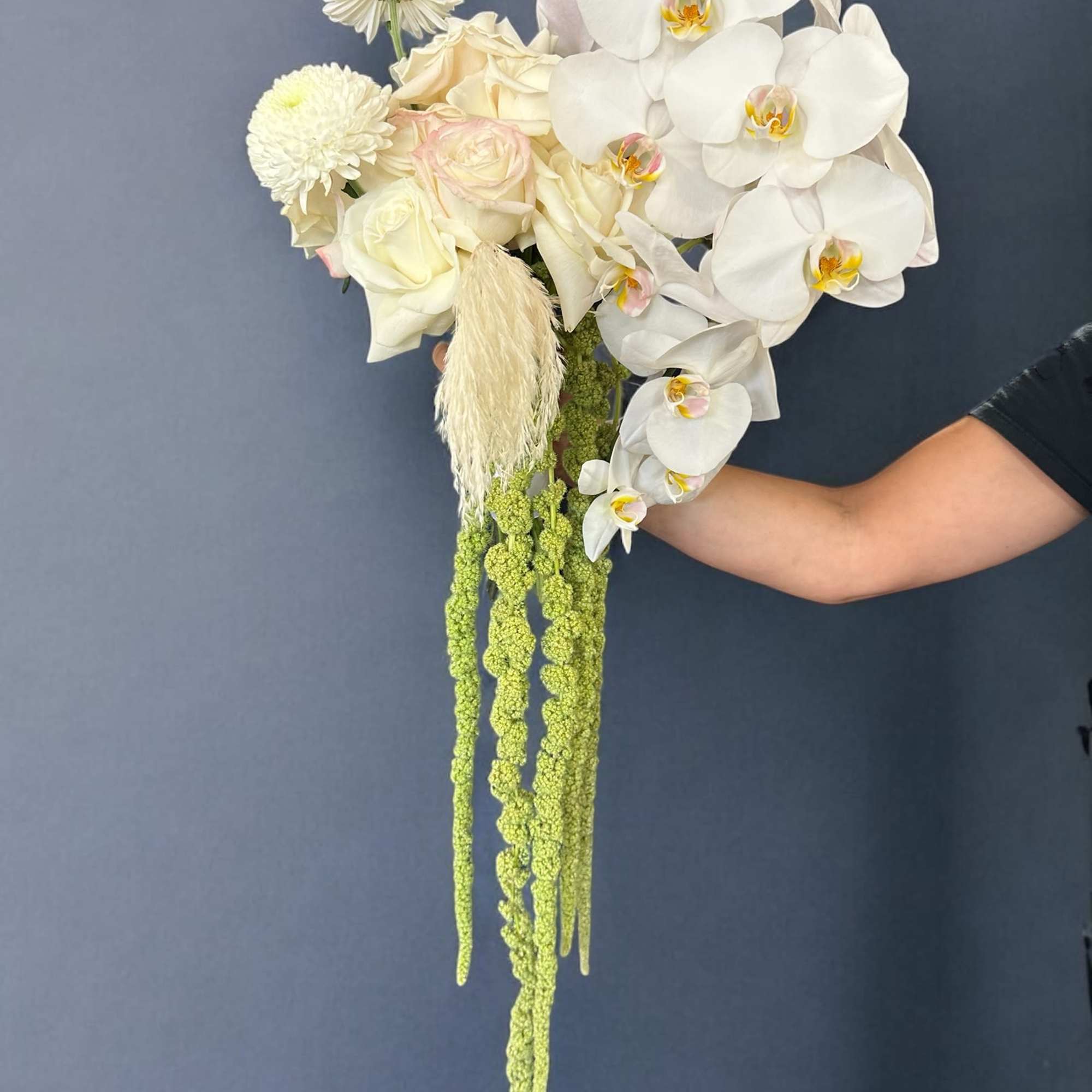 White orchid and rose bouquet with long green hanging accents