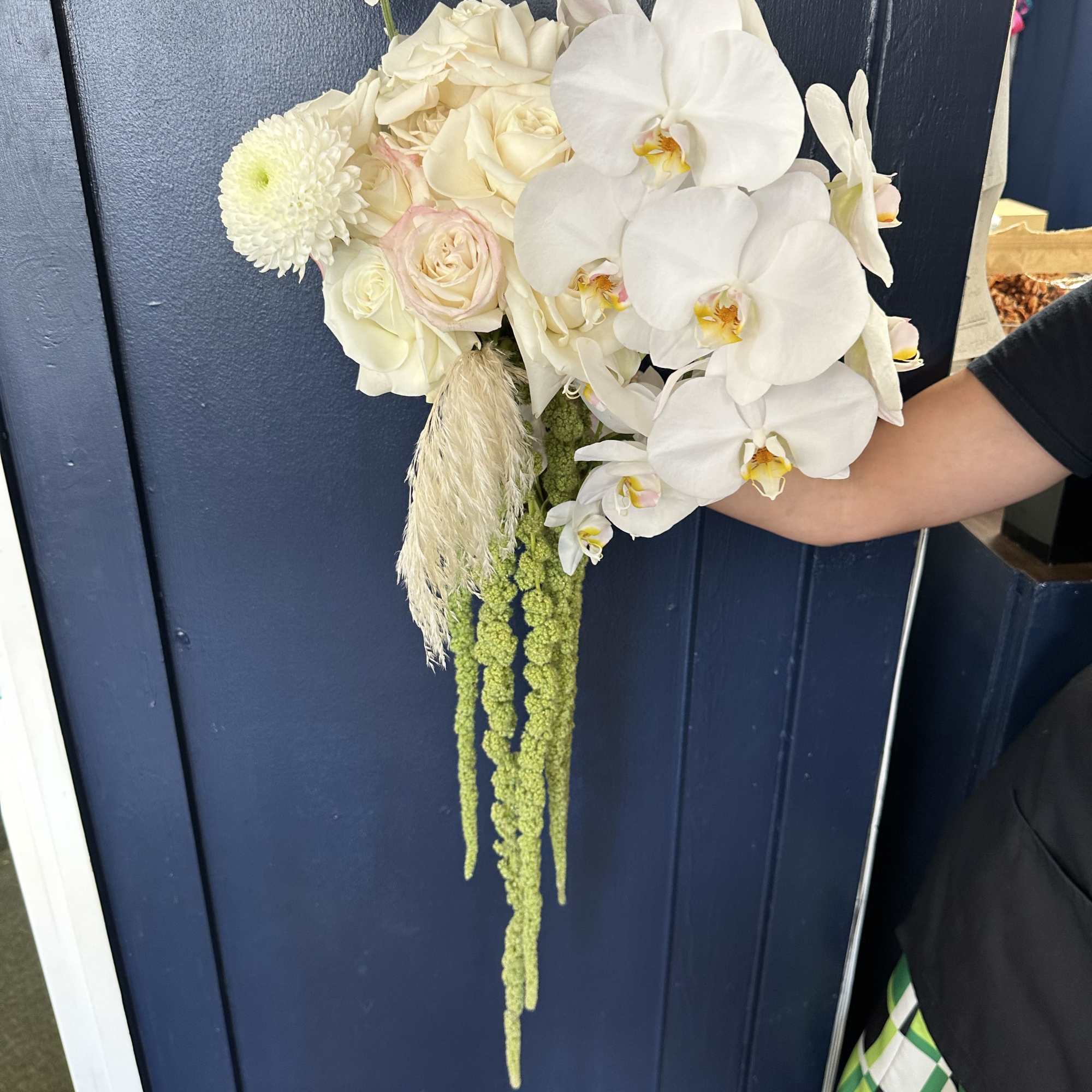 White orchid and rose bouquet with trailing green amaranthus