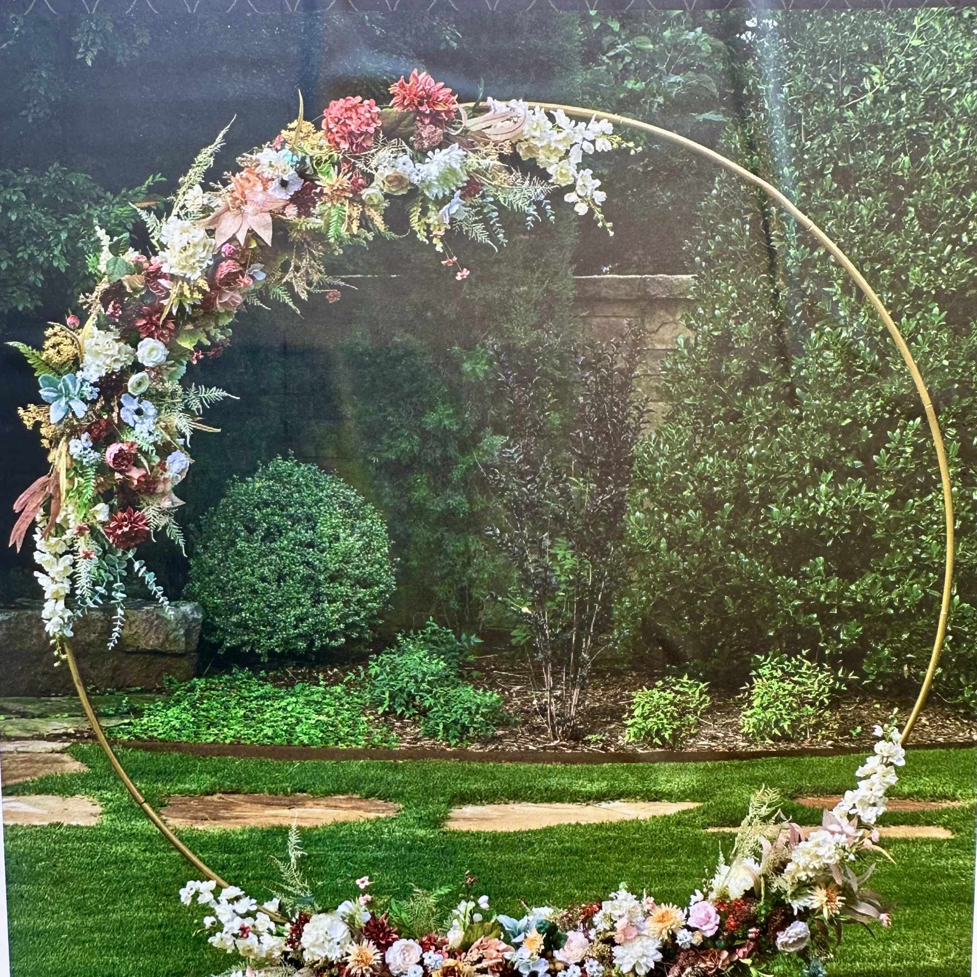 Floral arch arrangement on a gold metal hoop with pastel flowers
