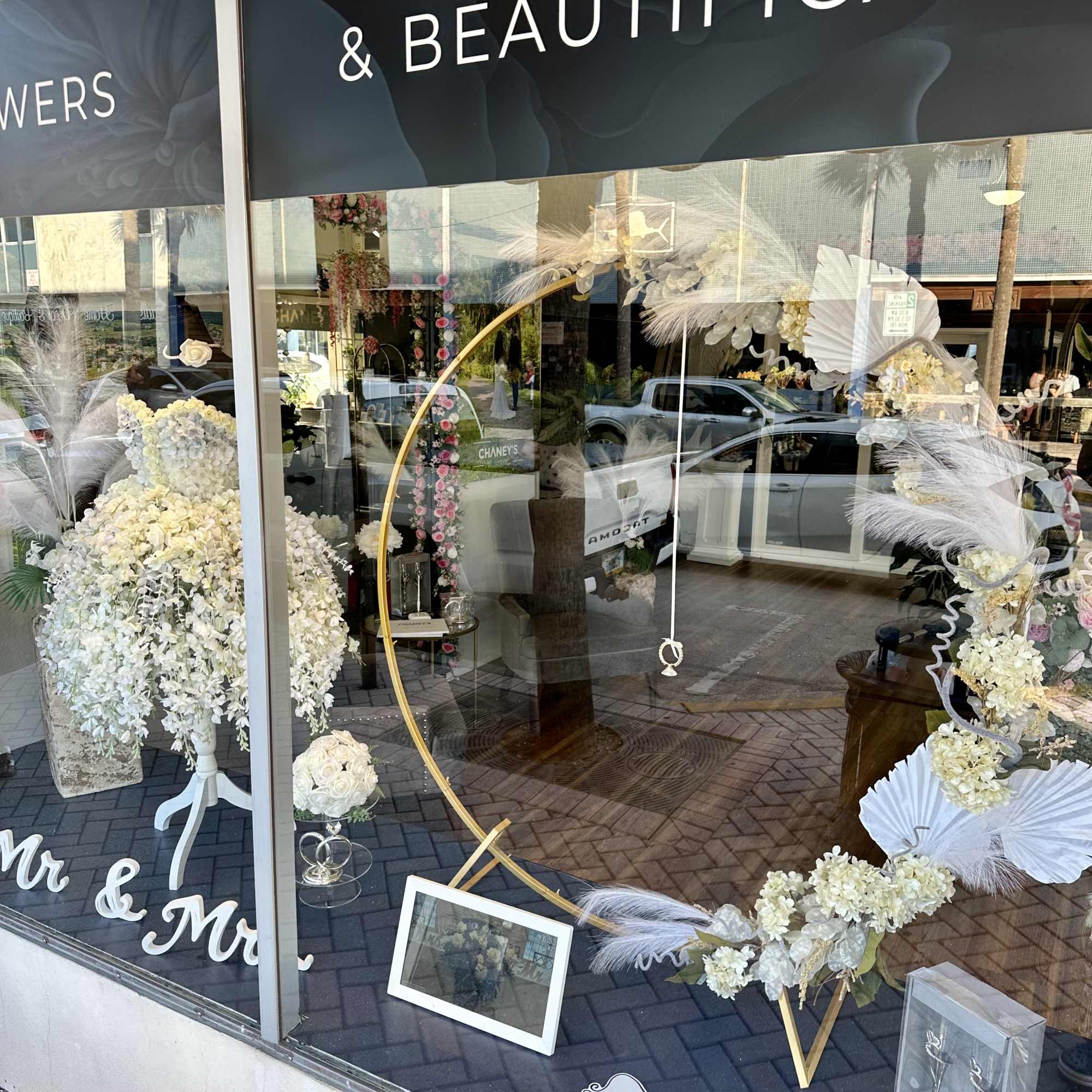White floral wedding display with a gold hoop and "Just Married" sign