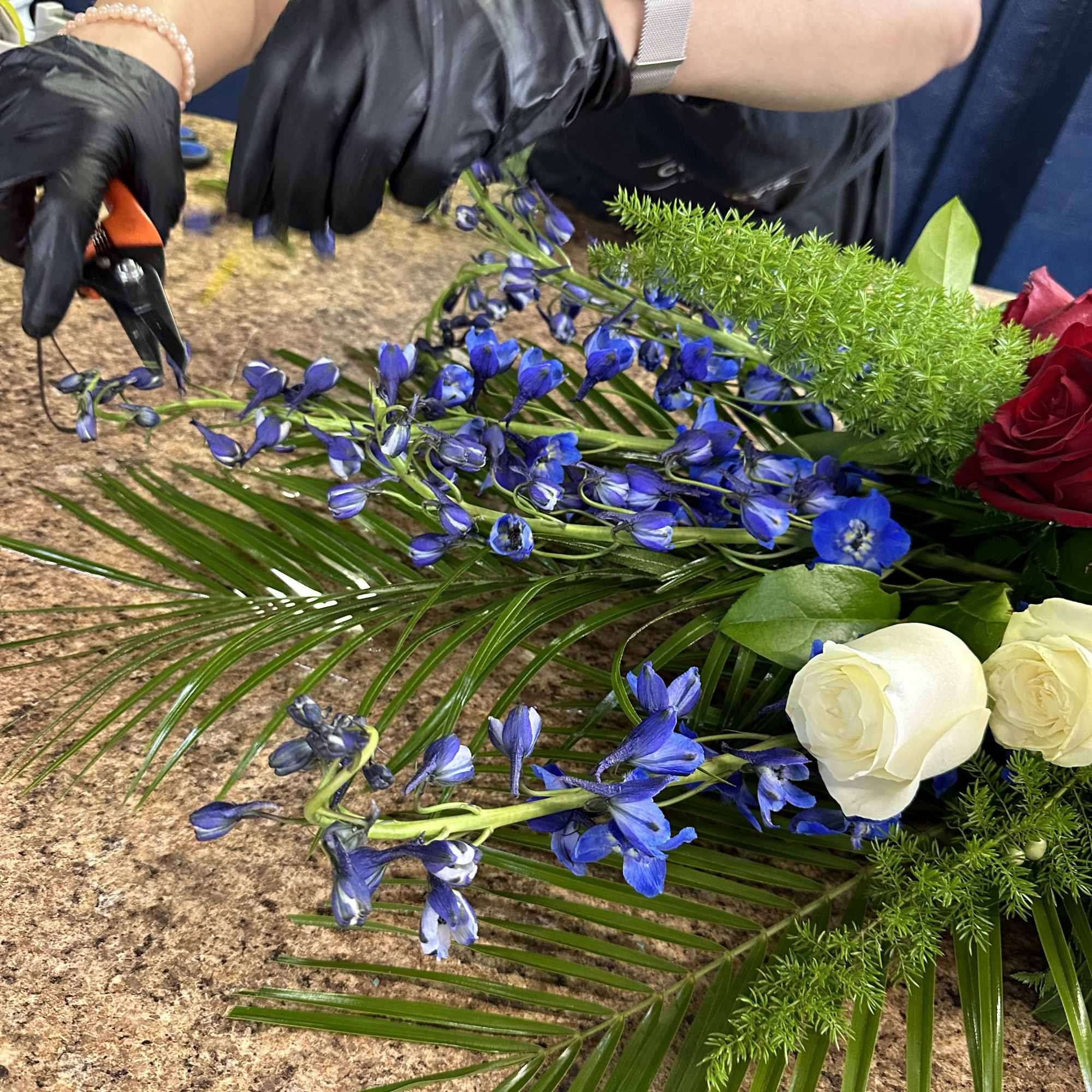 Blue flowers and white roses arranged on a worktable