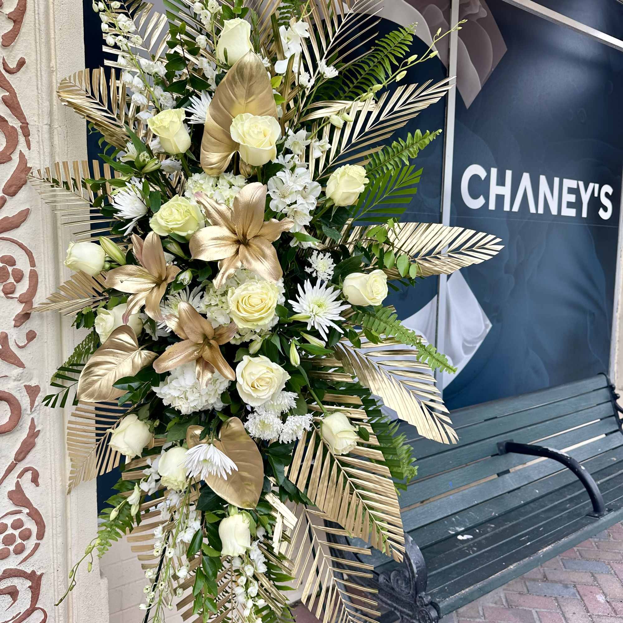 Tall white and gold floral standing spray with roses and lilies