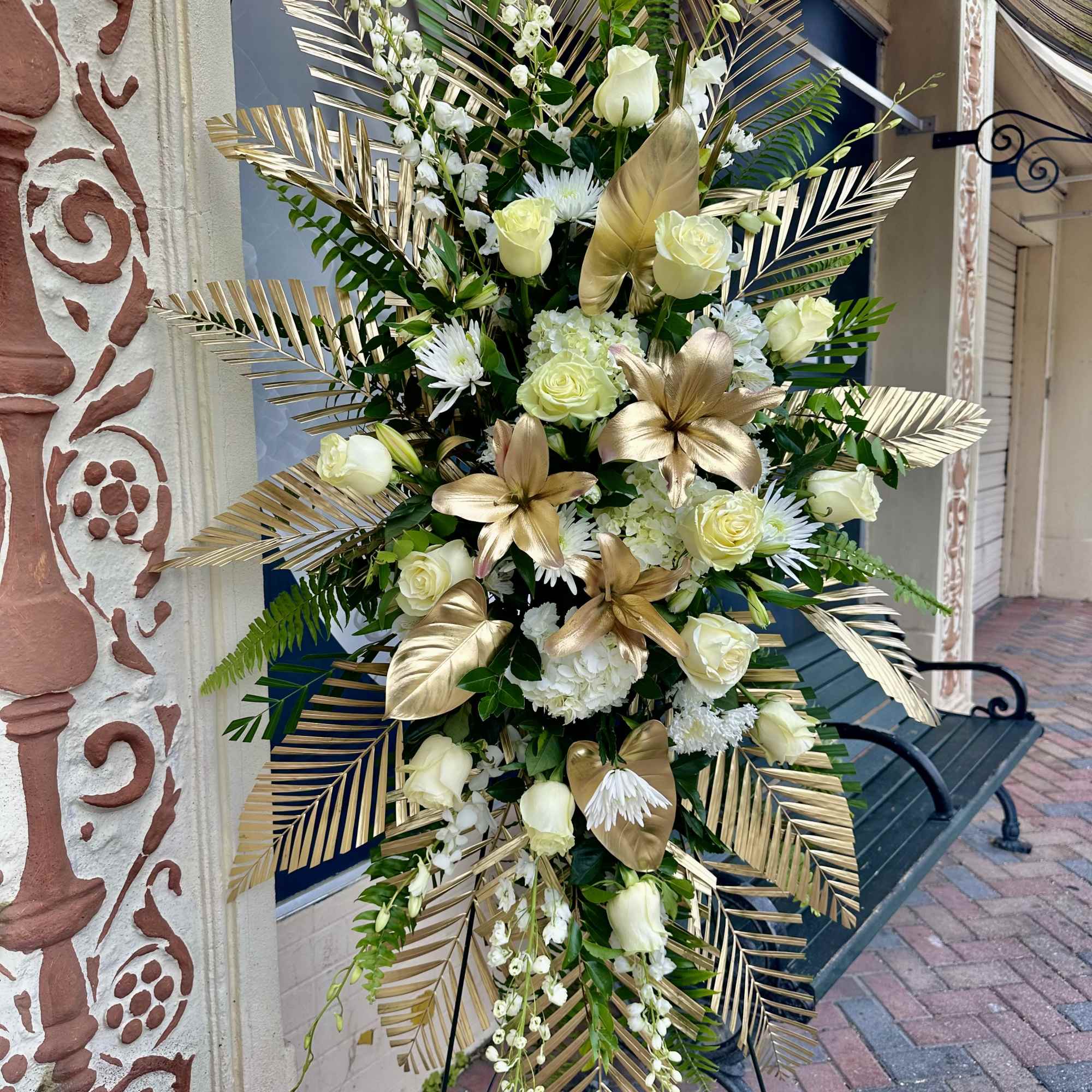 Tall white and gold floral standing spray on an easel