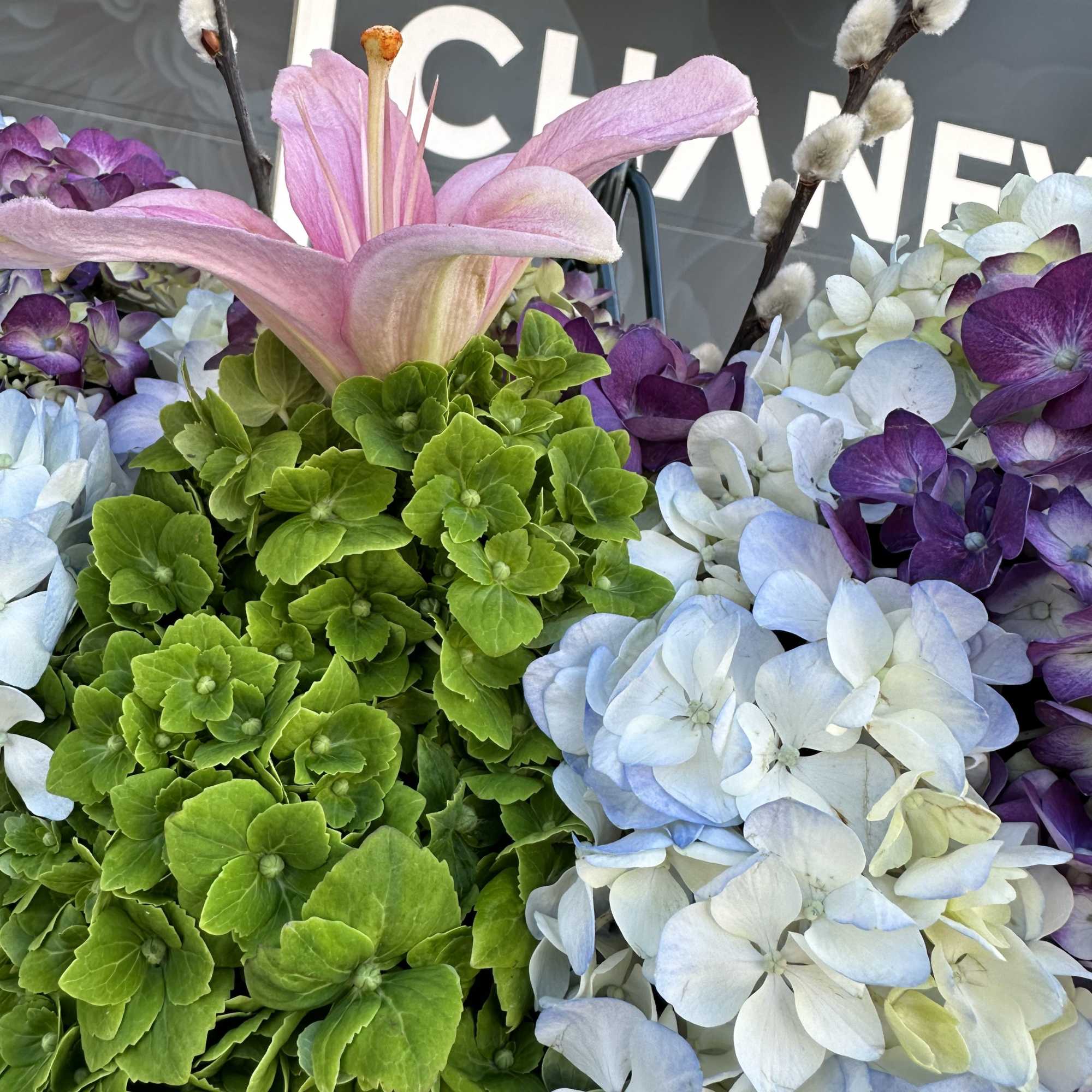 Bouquet of hydrangeas with a pink lily and pussy willow branches