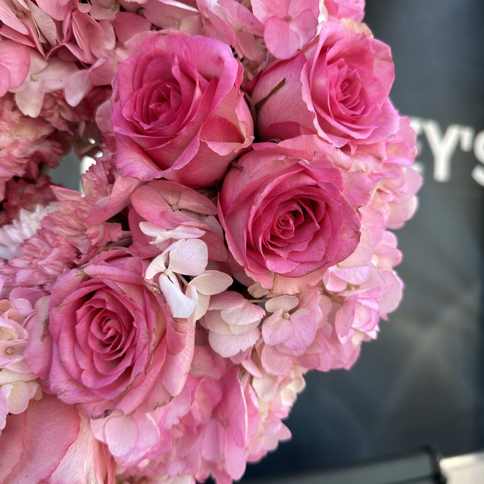 Pink roses and hydrangea blooms in a tight bouquet